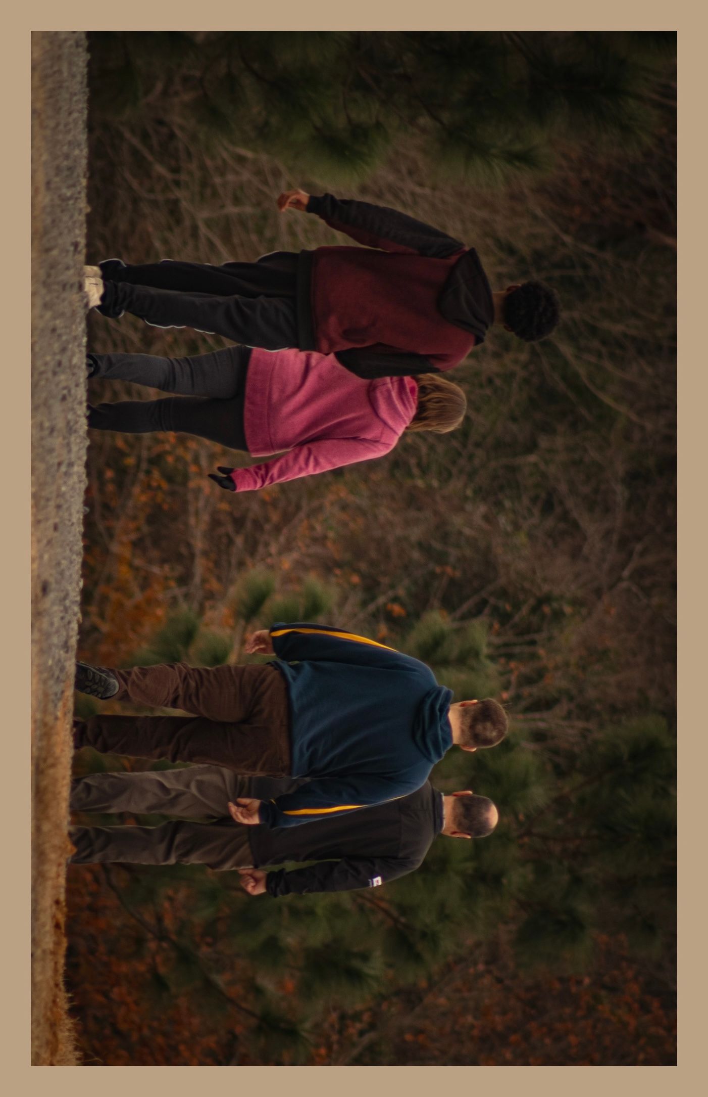 Three people walking together on a path in winter clothing.