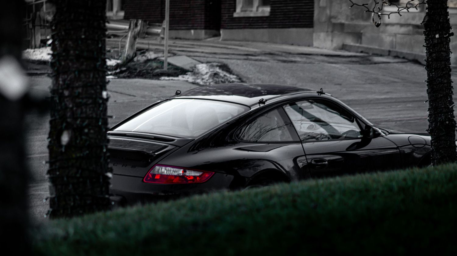 Low-key black and white photograph of classic Porsche 911 silhouette.