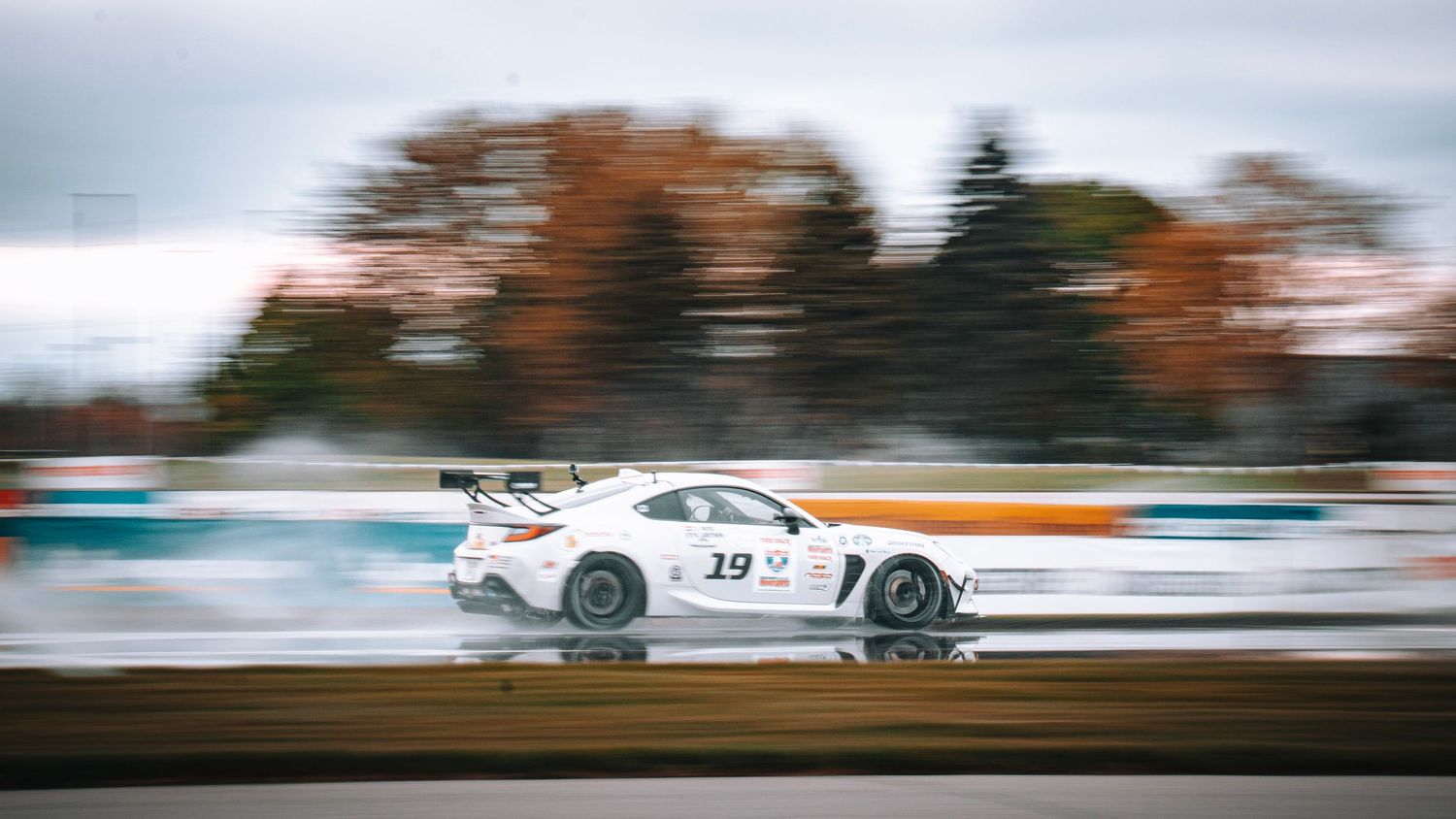 Race cars creating horizontal motion blur during high-speed competition.