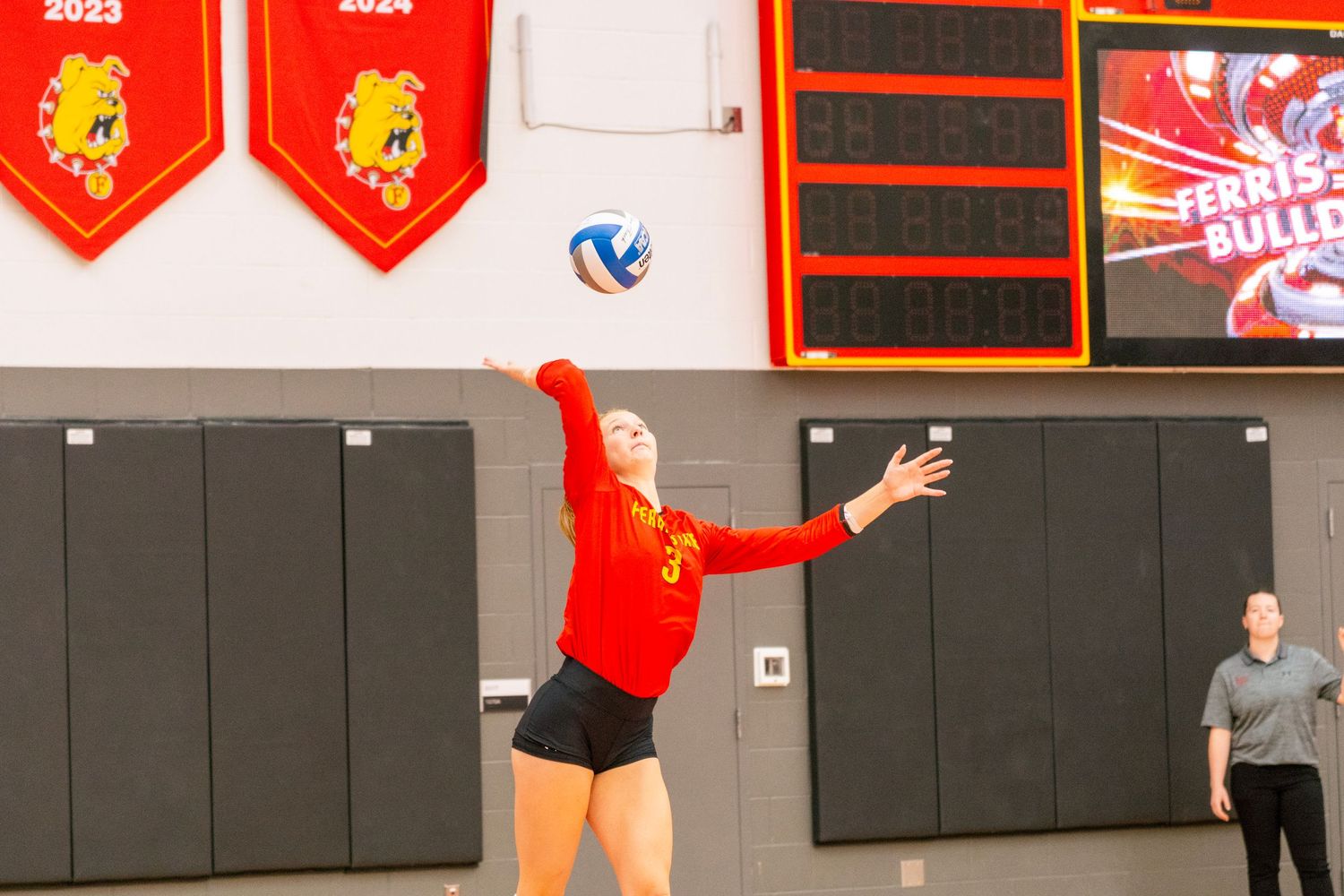 Volleyball team in red jerseys lined up on court during a competitive match.