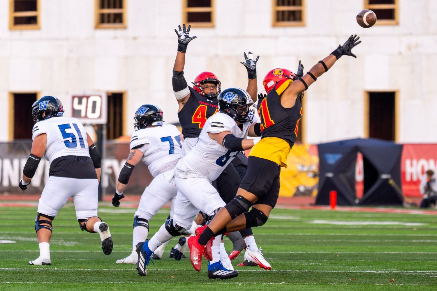 Football players collide and tackle during an intense defensive play on the field.