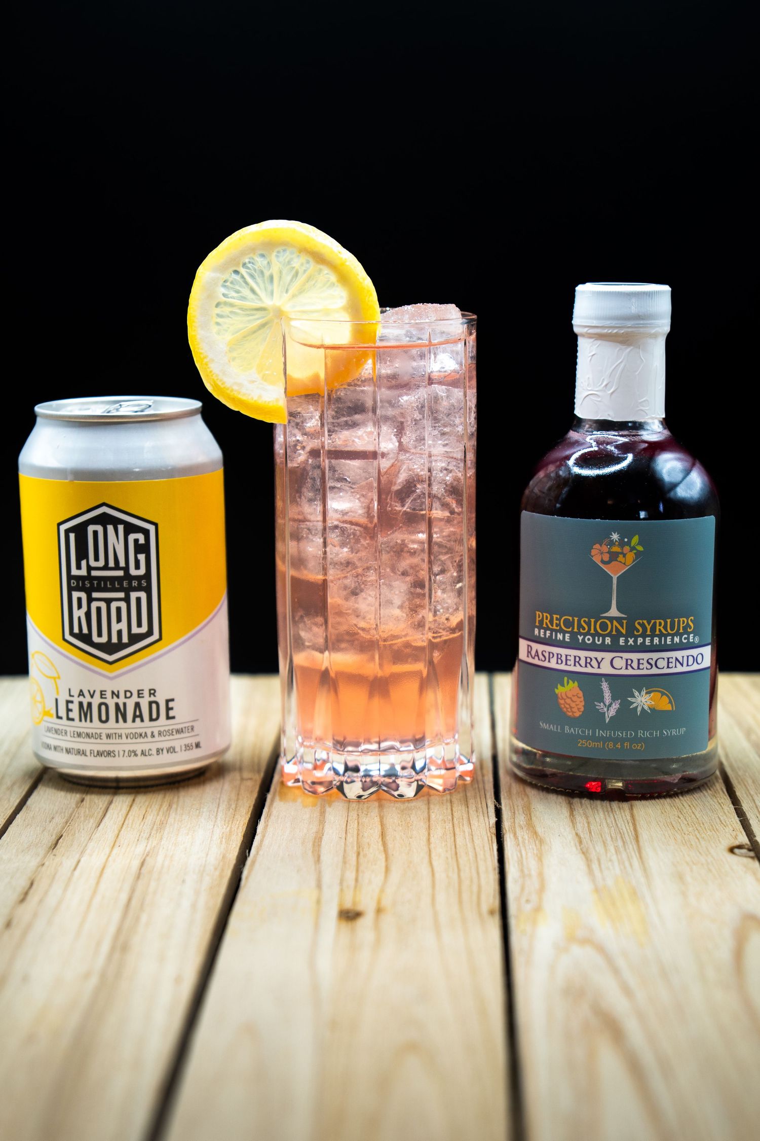 Craft cocktail arrangement featuring Long Road lemonade, garnished highball, and artisanal spirits bottle.