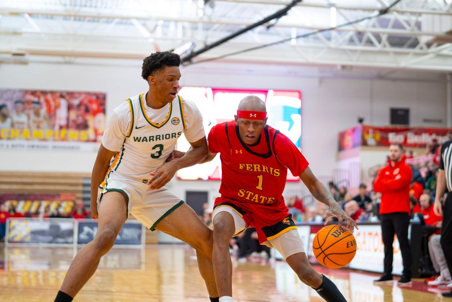 Basketball players compete for possession during an intense game between red and white uniformed teams.