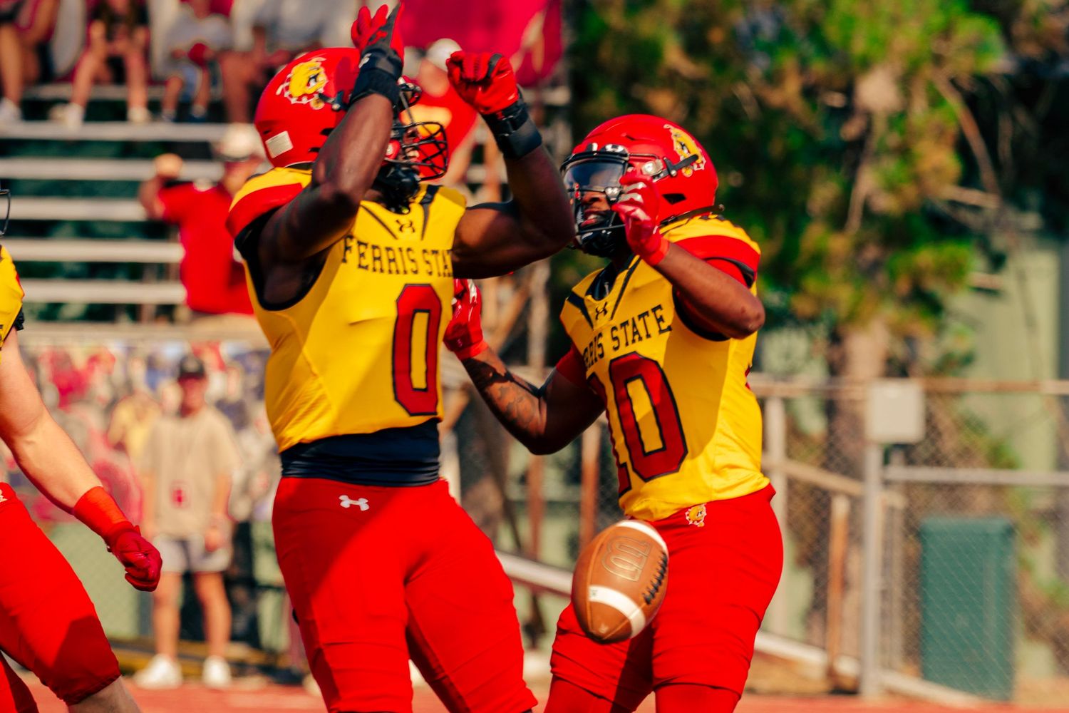 Baseball players in red and yellow uniforms celebrate on the field during a game.