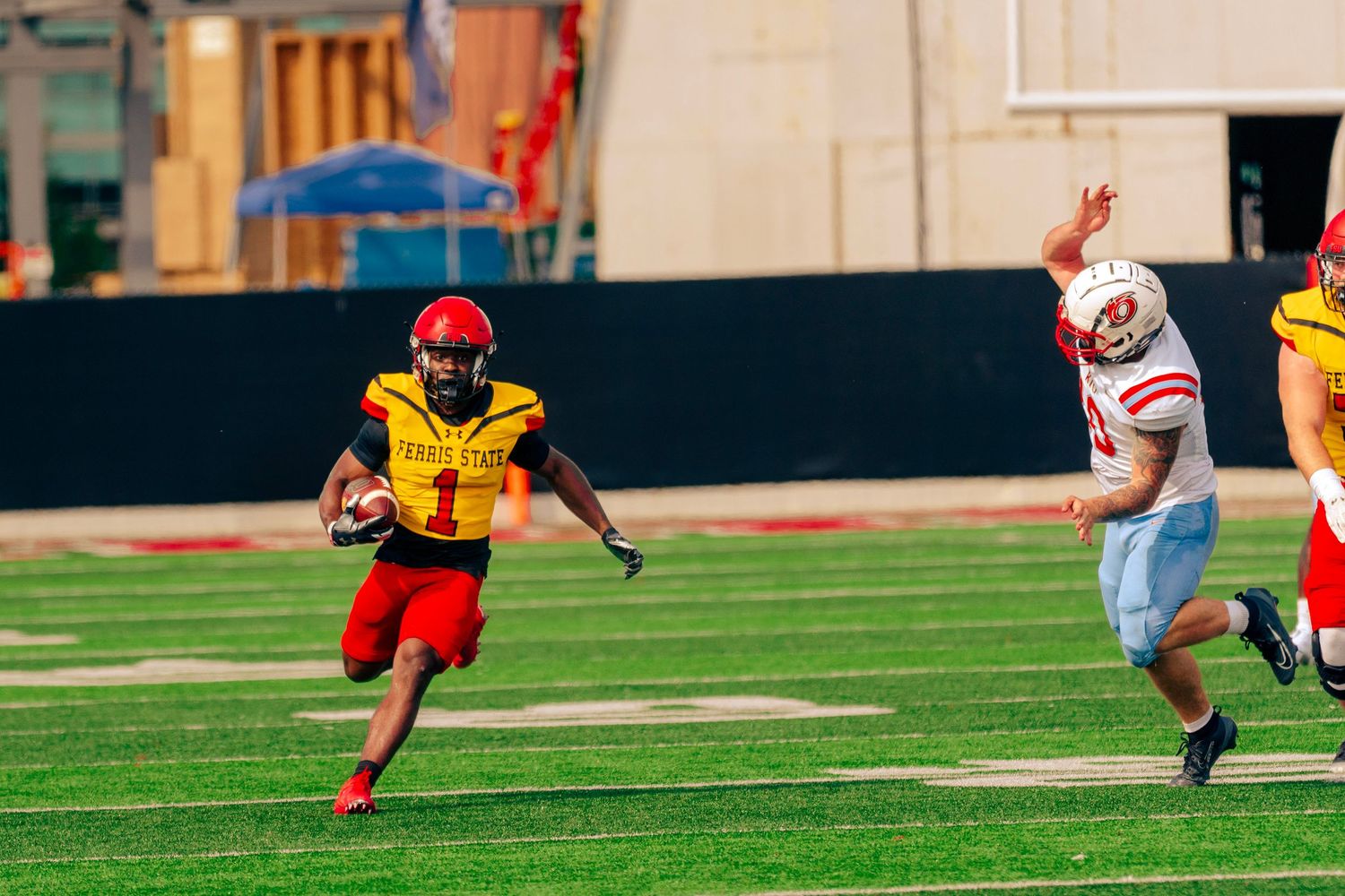 Football player in red uniform dives forward to make a play on the field during an intense game.