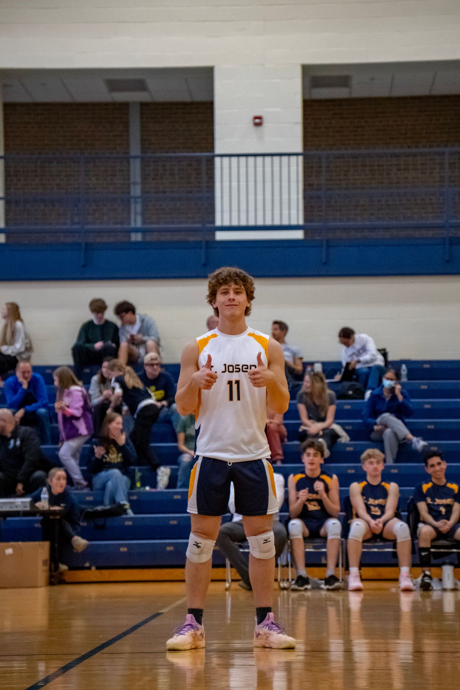 A volleyball player wearing number 11 stands ready on the court during a match.