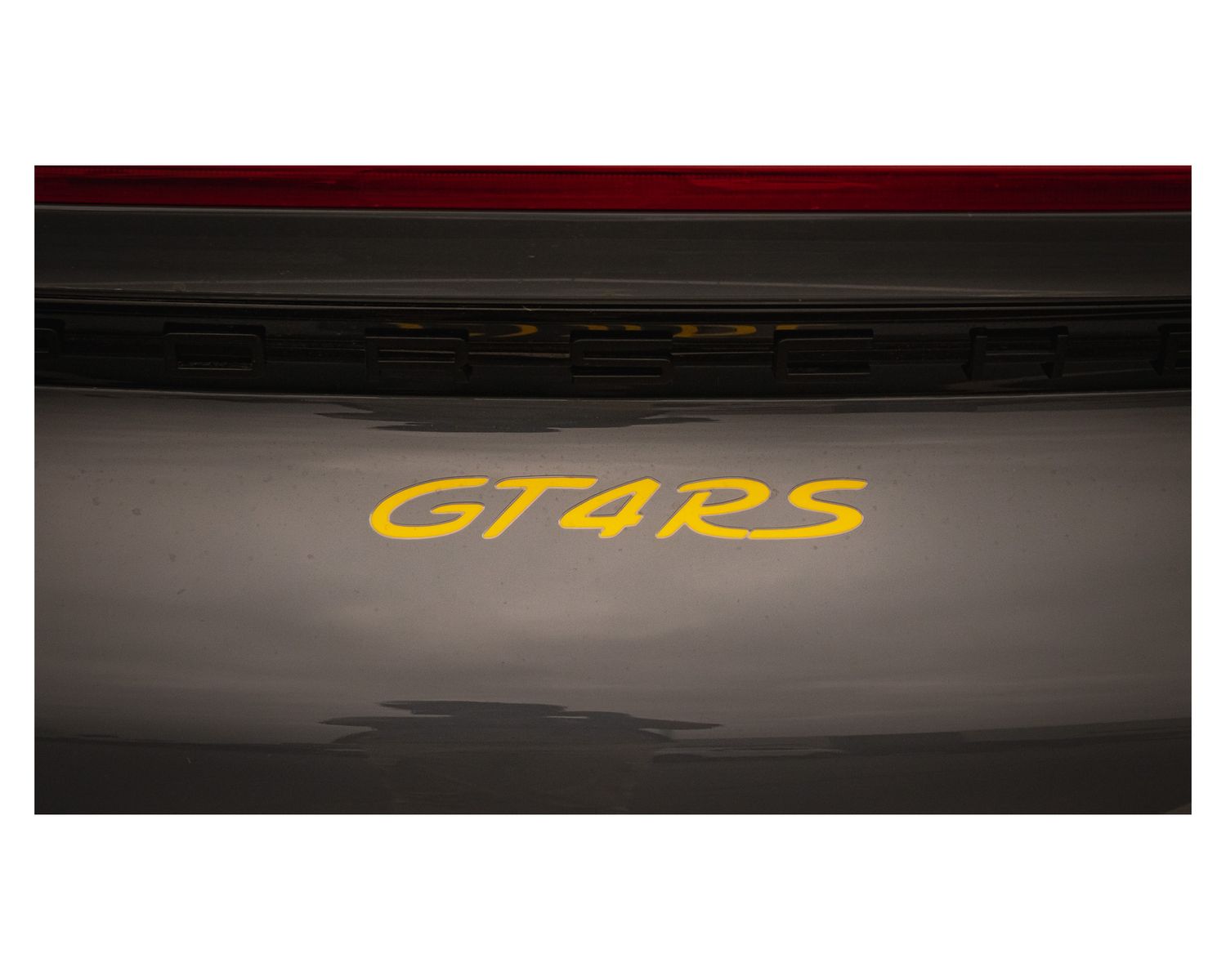 Close-up shot of GT4RS yellow lettering on a dark surface.