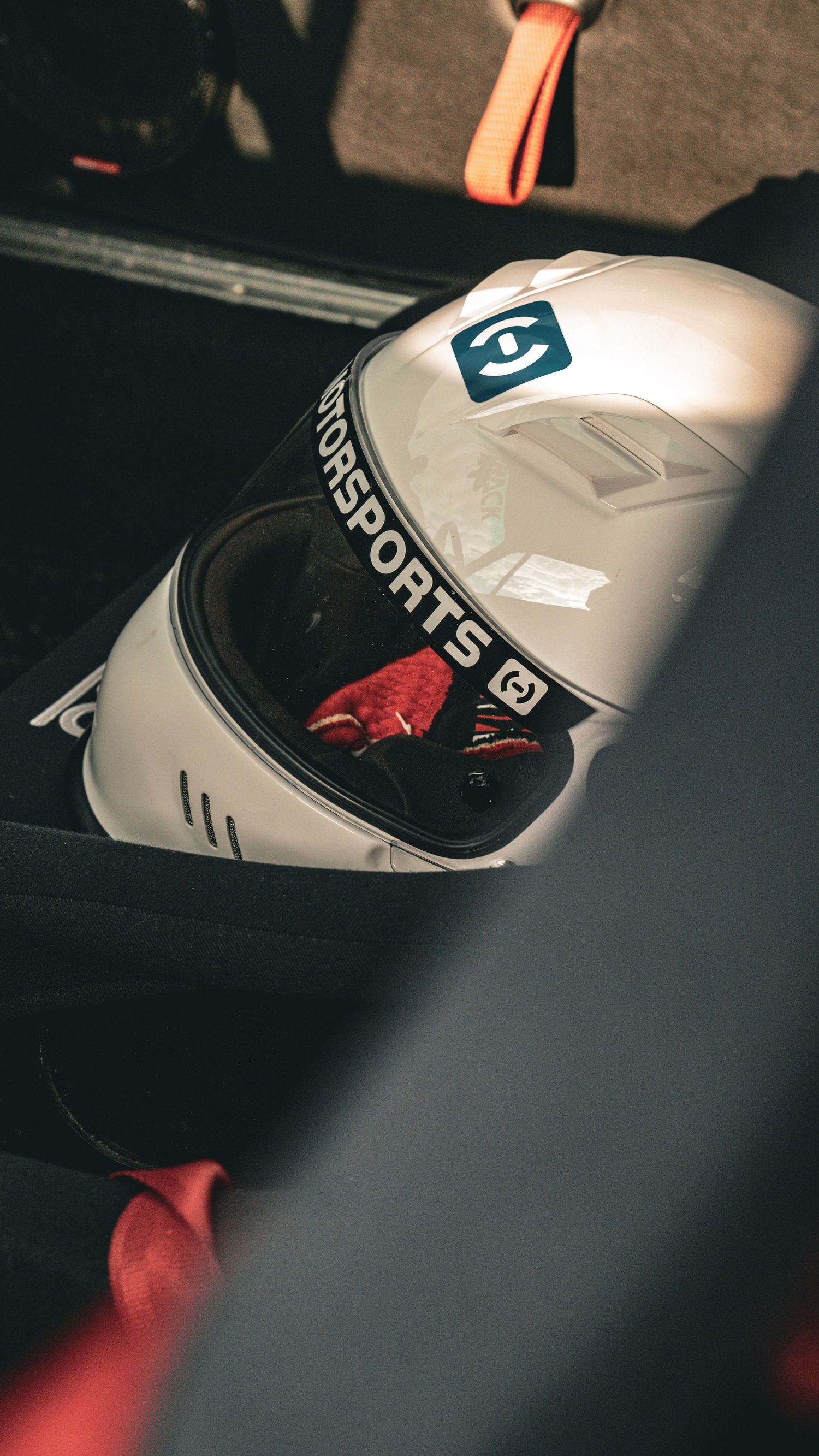 Racing helmet with sponsors' logos photographed in dramatic low-key lighting.