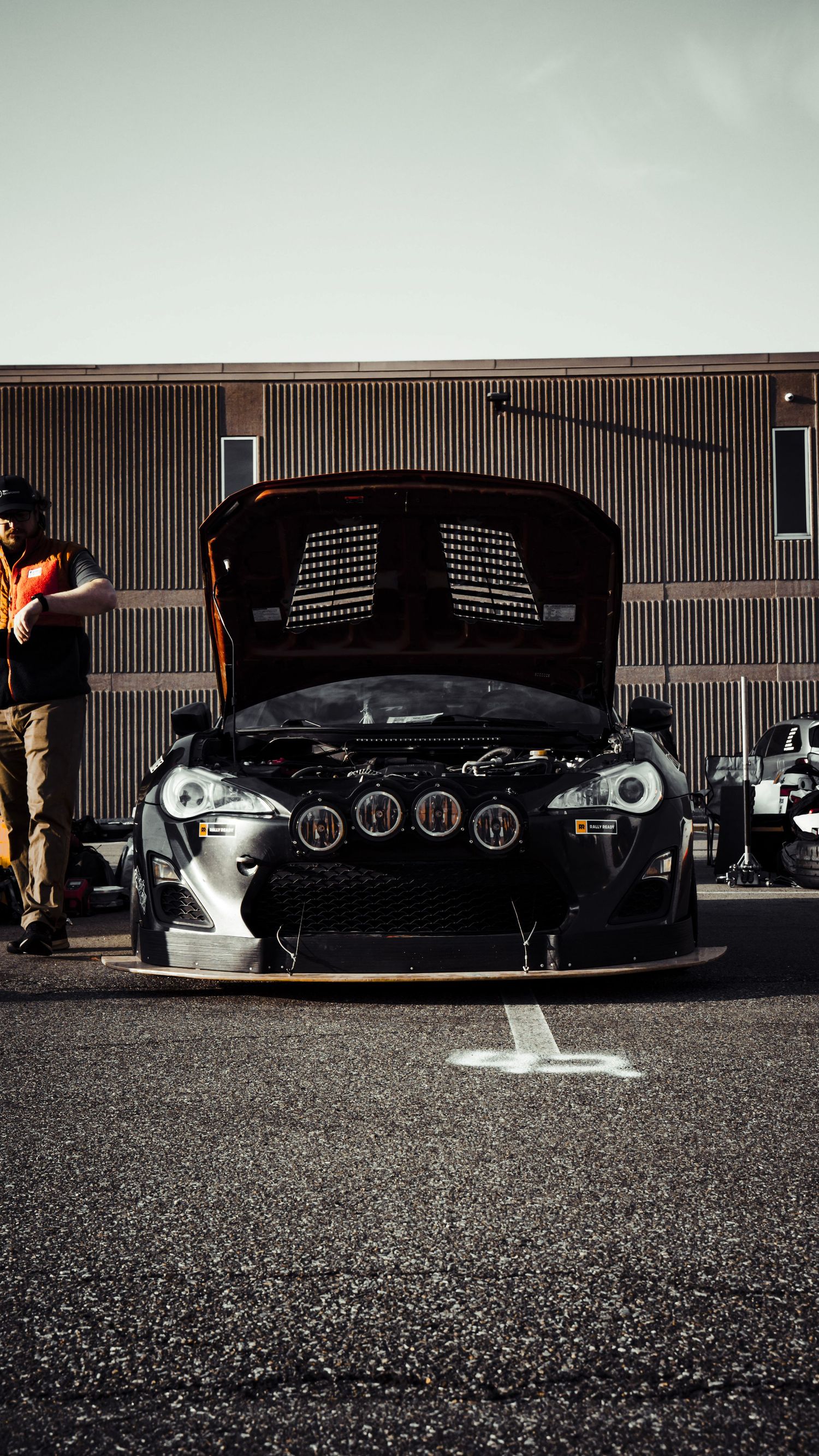 Modified black Toyota with open hood showing performance engine modifications.
