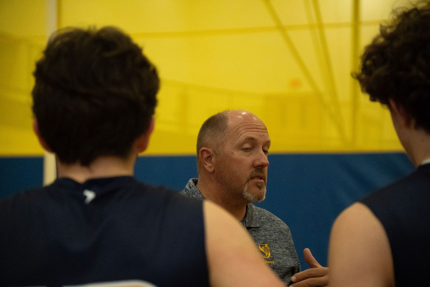 Coach gives instruction to volleyball players during a game break.