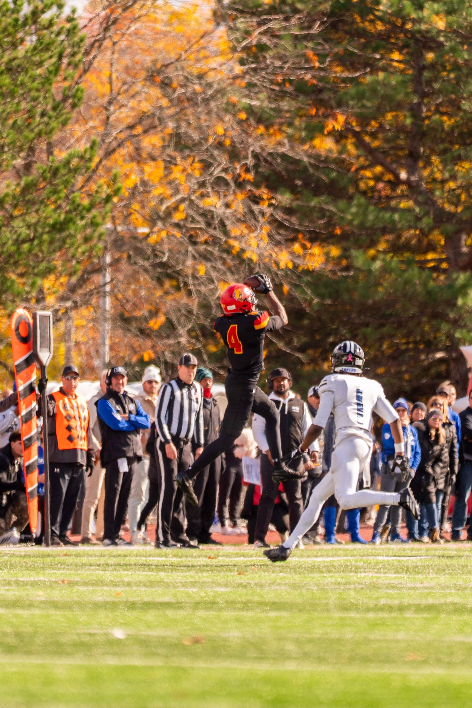 A sequence of football players performing athletic flips and acrobatic moves on a grassy field during a game.