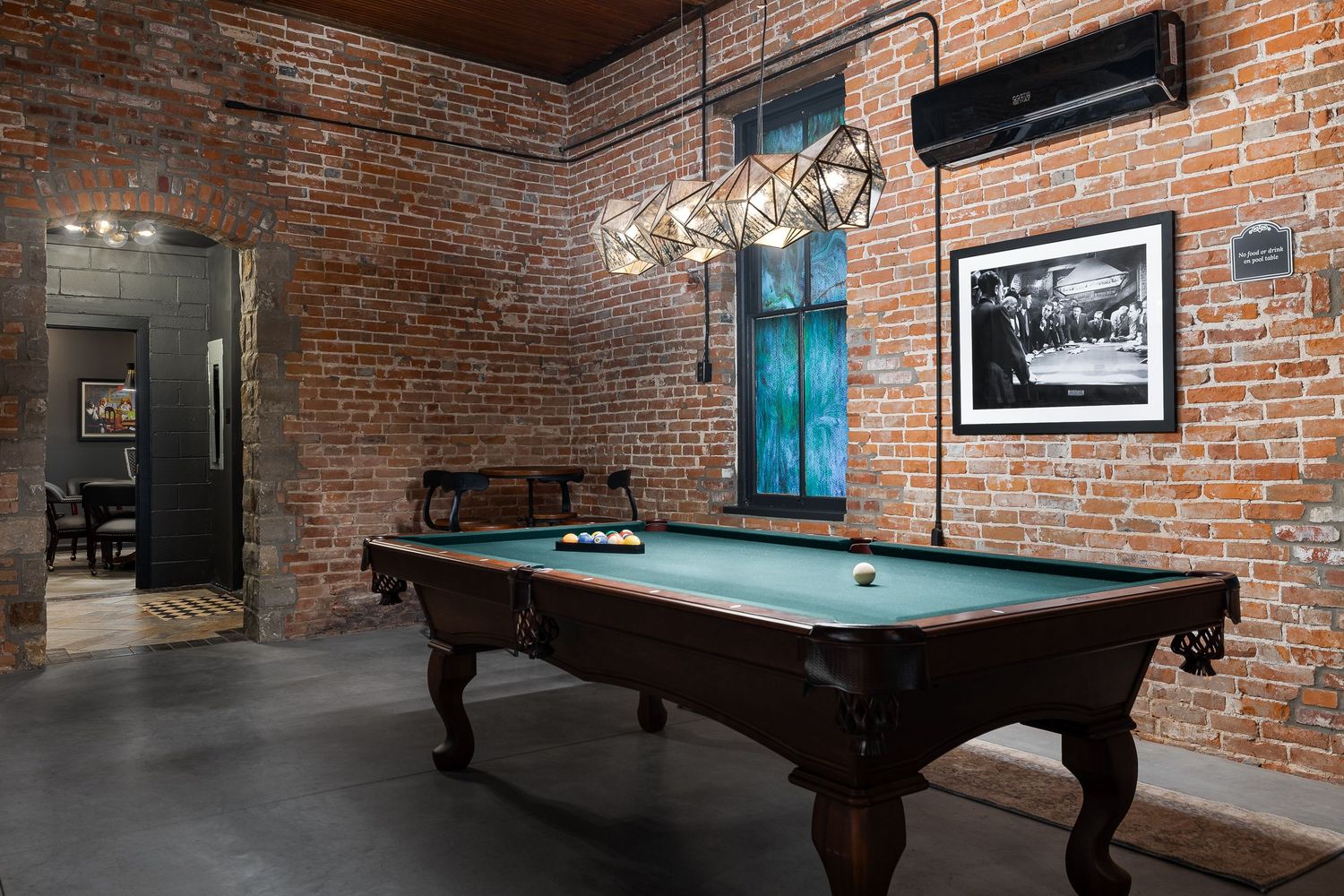 Industrial style interior with pool table and original brick. Photo produced by Derek Mecca showcases the church renovation in Eudora KS