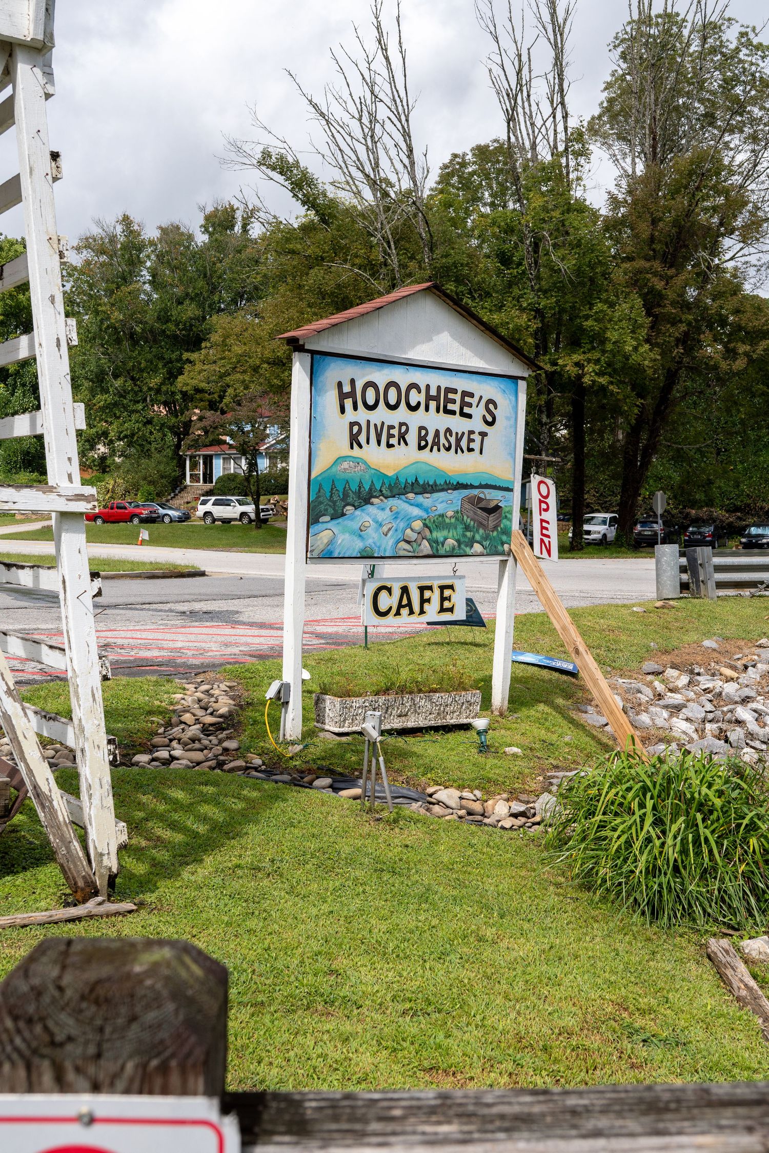 A restaurant sign is shown in a retro style with green vegetation around. An example of restaurant photography candid-style.