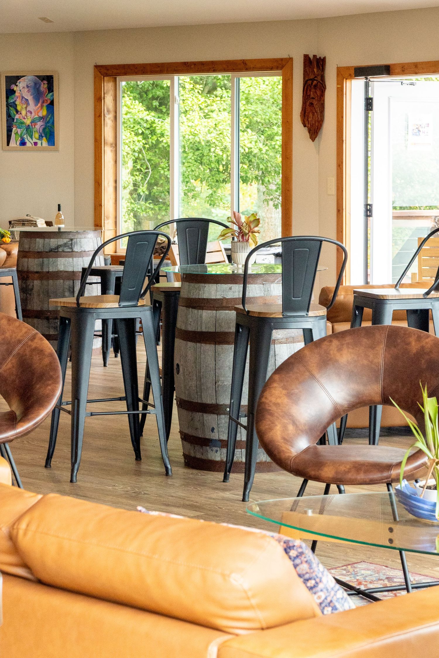 A bright winery tasting room is shown with leather furniture and metal accents inspiring a comfortable, cozy retreat
