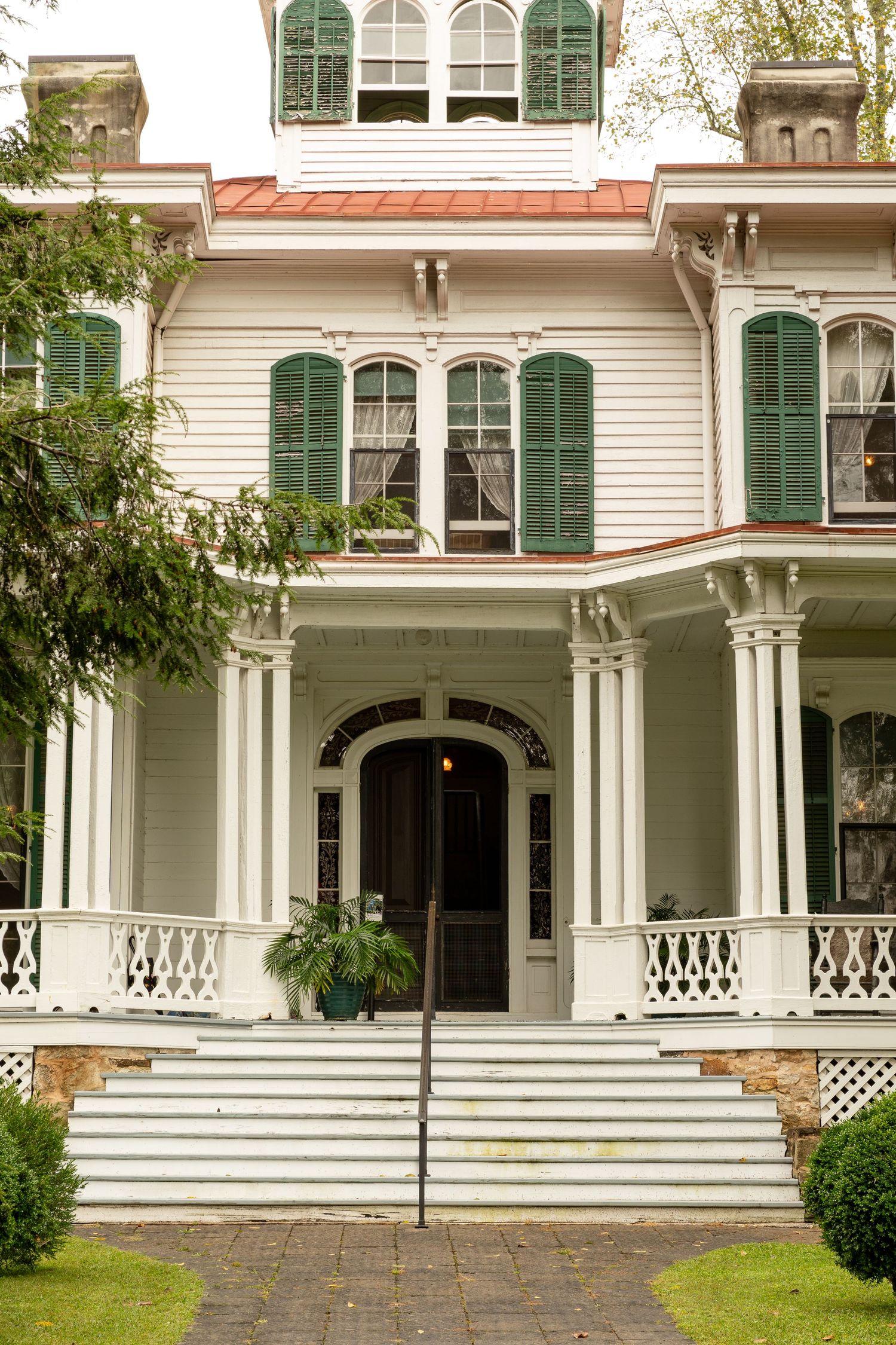 An old italian mansion sits grandly centered in the photo. The photo radiates grandeur and southern hospitality and local culture.