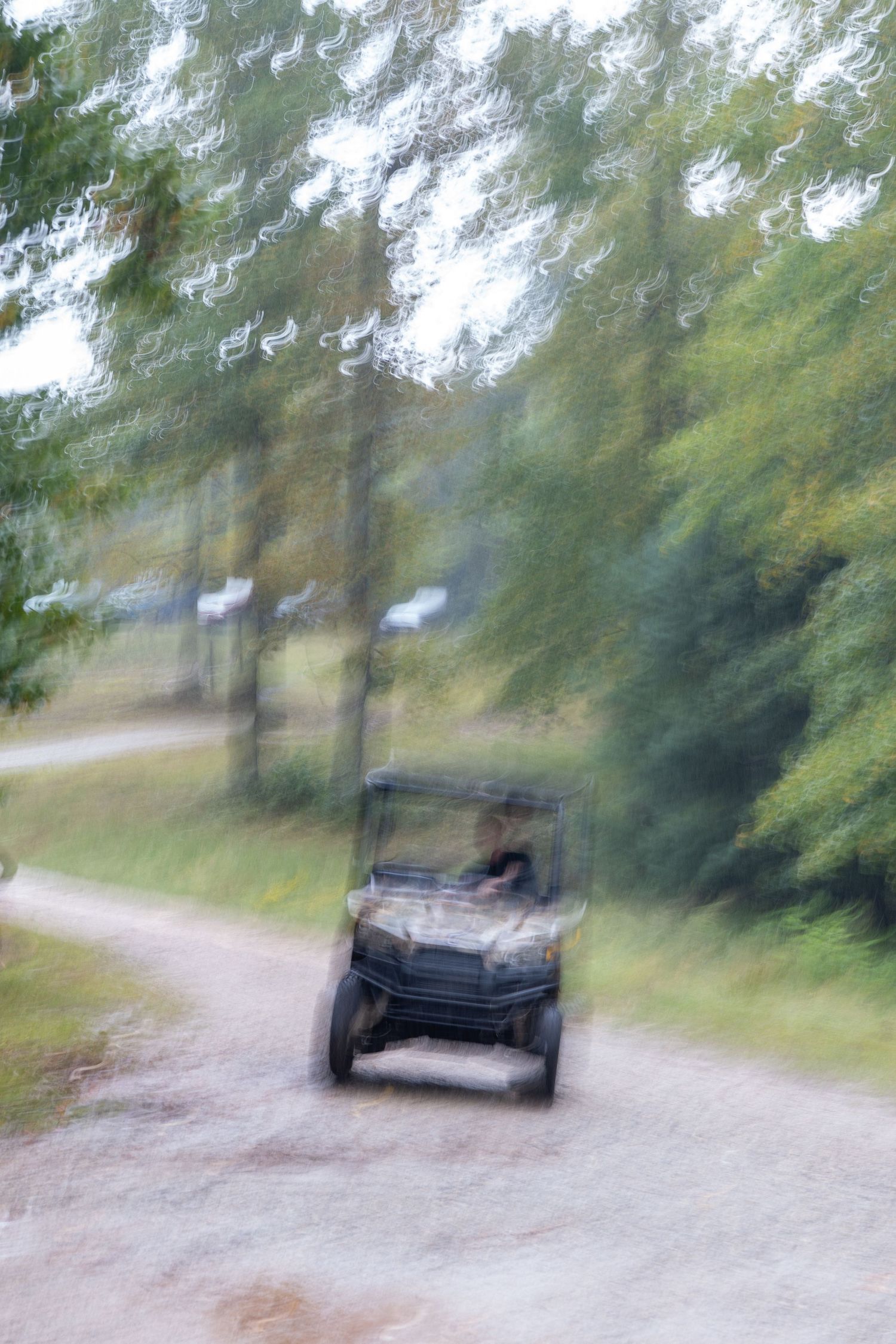 A blurred photo inspiring adventure of a person driving an ATV in the rain.