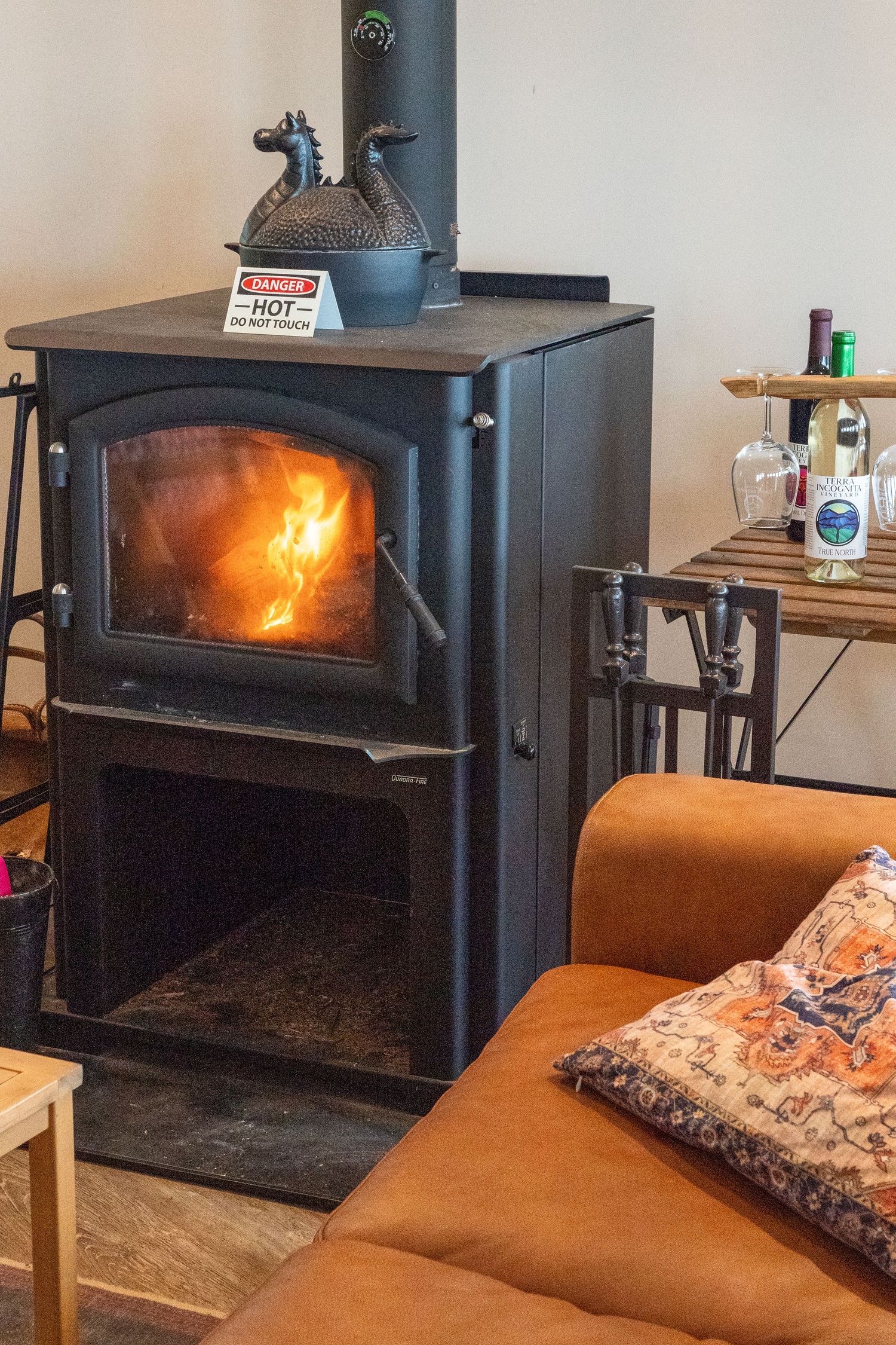 A warm fire burns within a stove inspiring outdoor adventure, cozy accommodations, and travel memories.