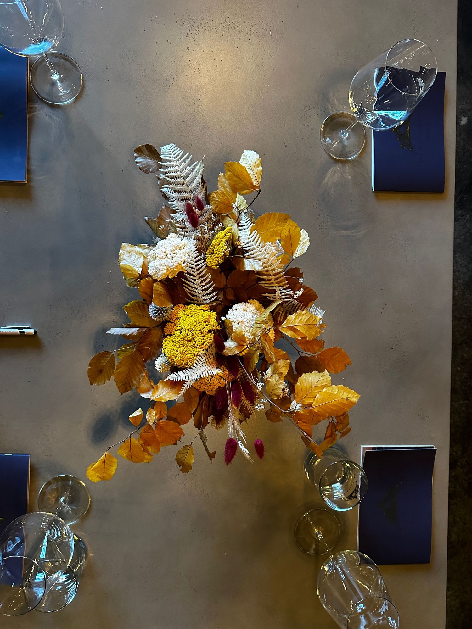 dried floral arrangement in yellow, burgundy, and gold tones, on display on a table in a local wine tasting room in Paso Robles Tin City