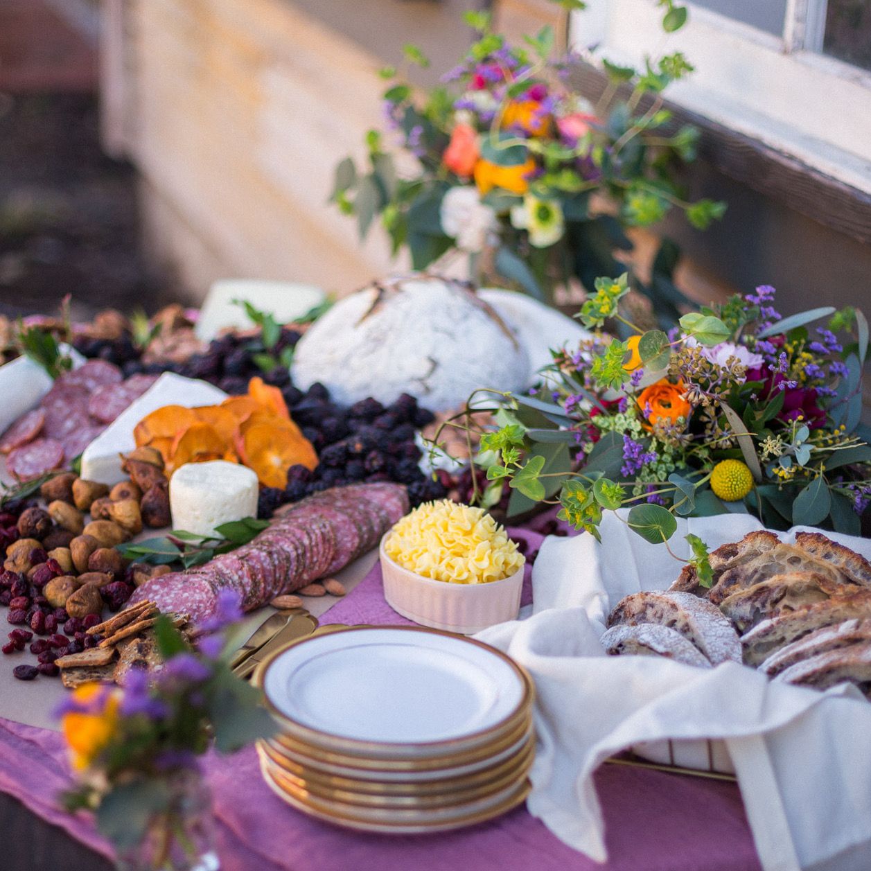 colorful flower arrangements displayed on an artisanal food table