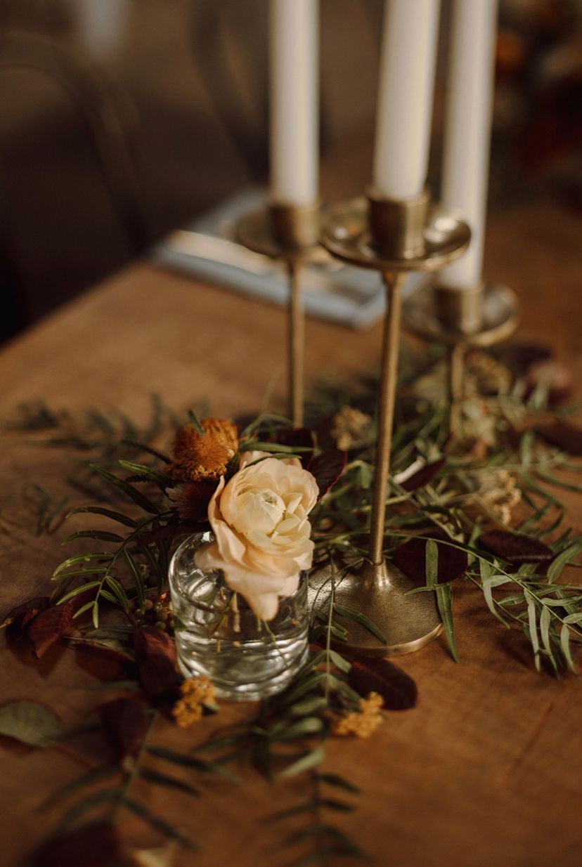 flower arrangement on table with golden candlesticks - gold, orange, peach color tones at a wedding venue in San Luis Obispo, California