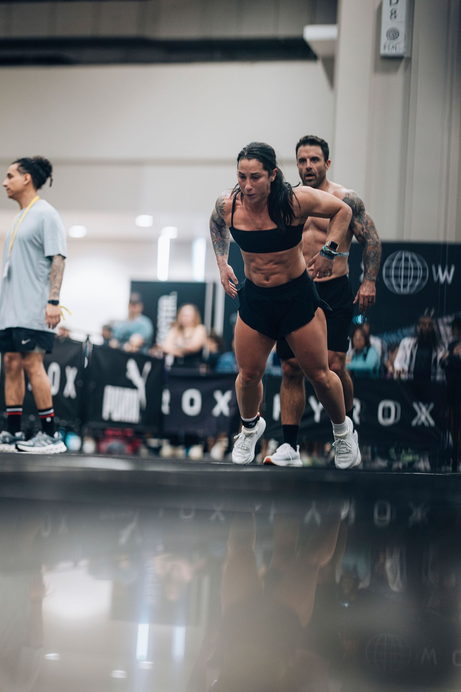 Athletes performing intense CrossFit exercises in a modern gym facility.