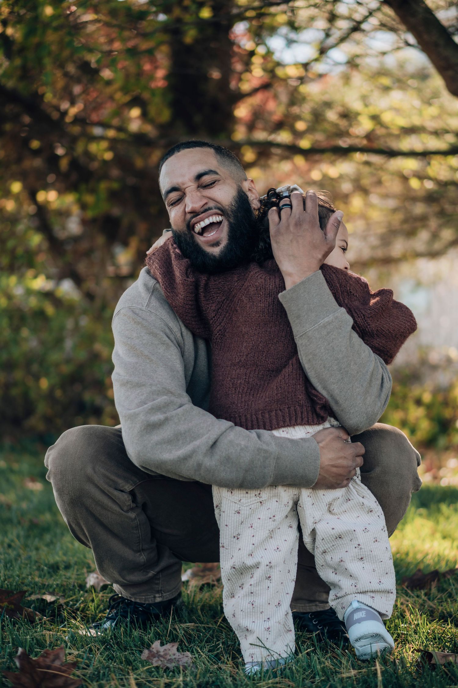 A sequence of candid outdoor portraits showing joyful expressions and laughter while sitting on grass in autumn lighting.