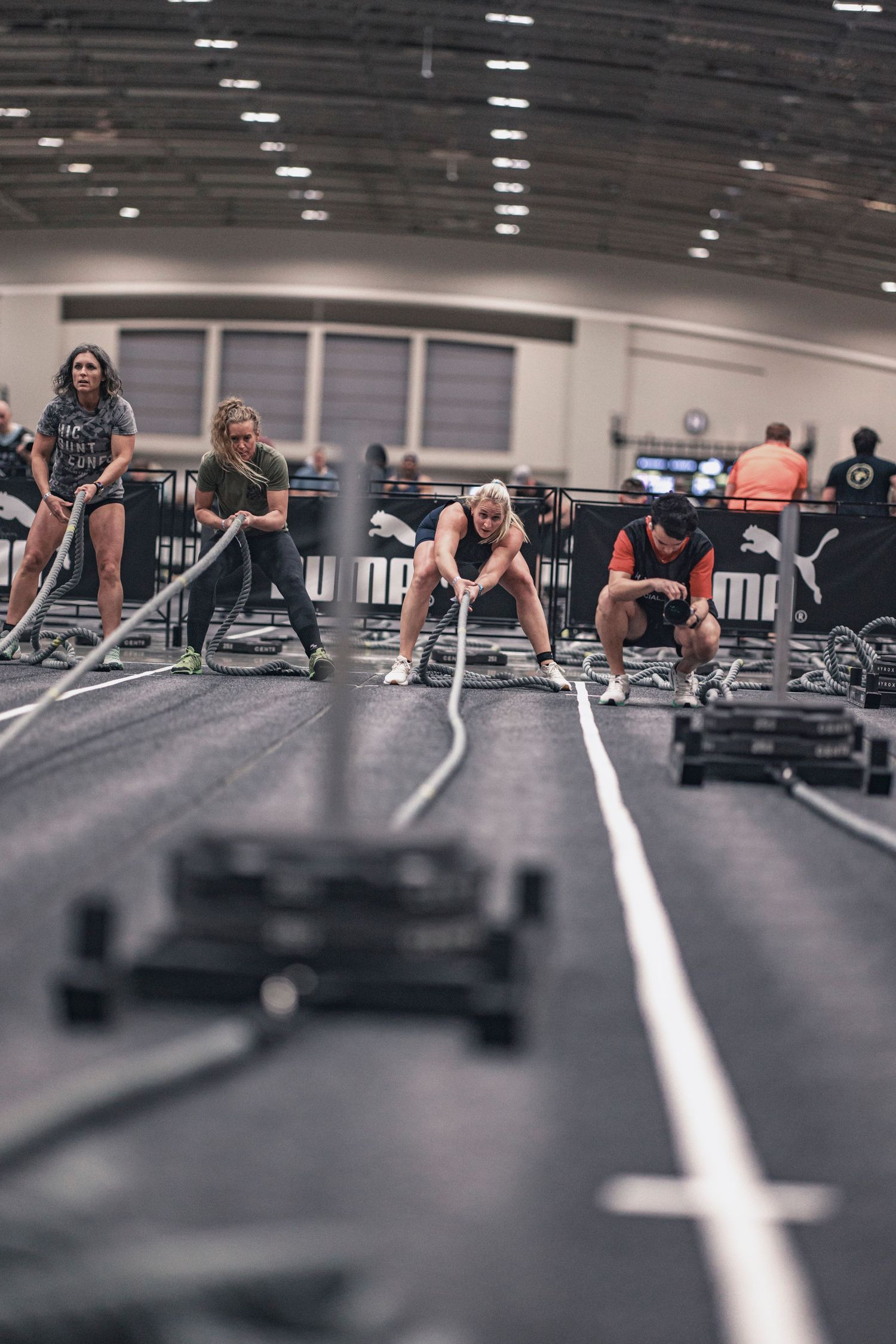 Low angle view of people exercising on gym floor with fitness equipment and white lines.
