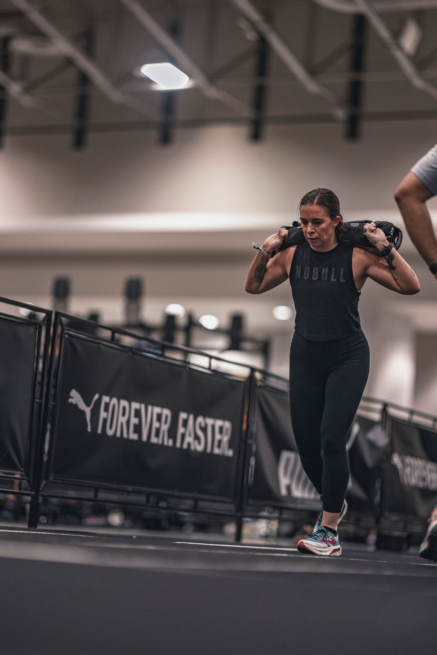 Person jumping over obstacle during high-intensity workout in modern fitness facility.