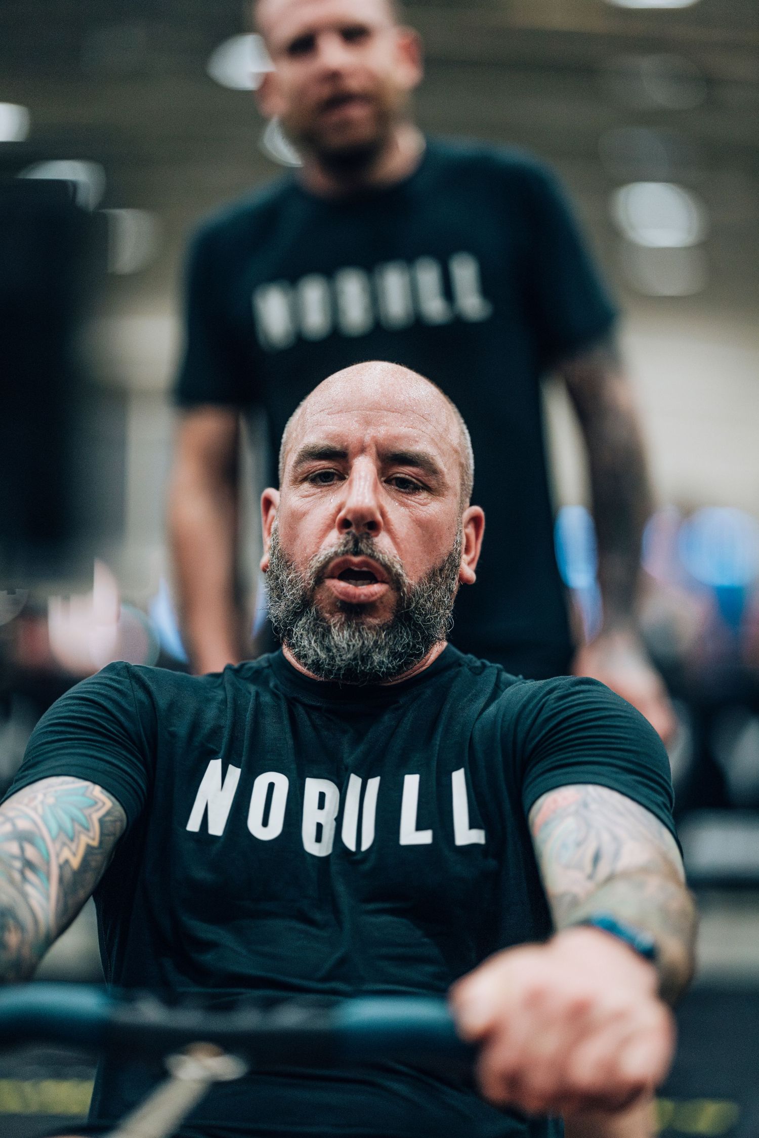 Person in black 'No Bull' t-shirt working out at a gym facility.