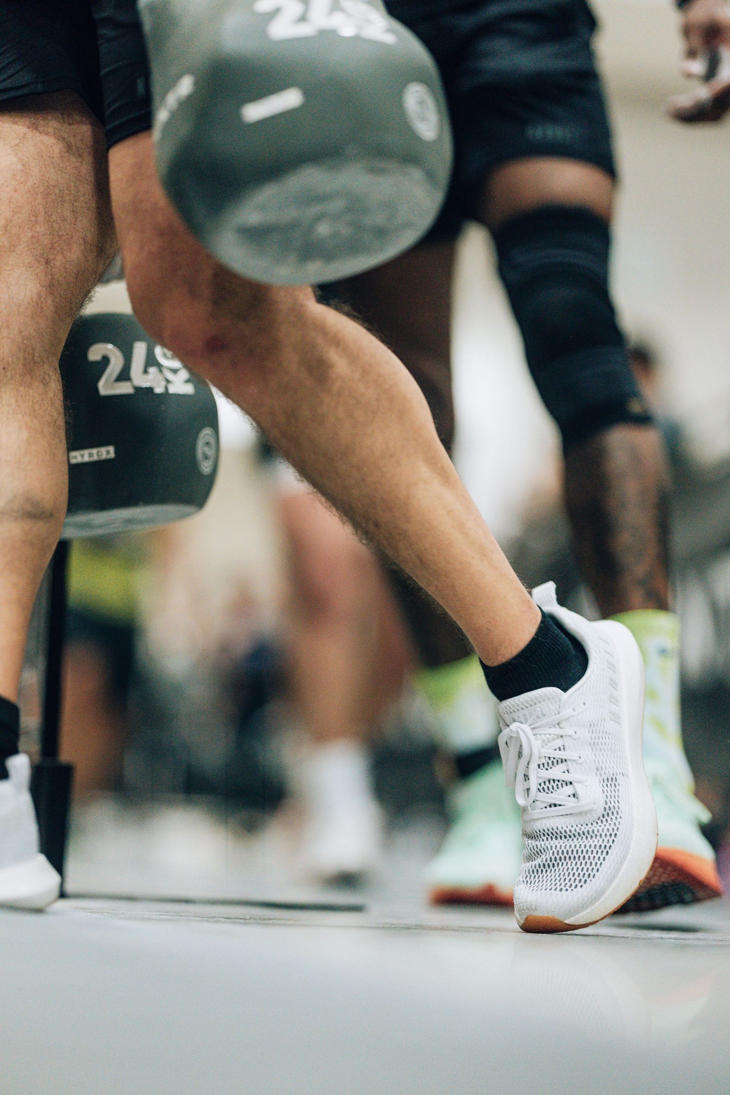Close-up of white athletic shoes and workout gear during gym training.
