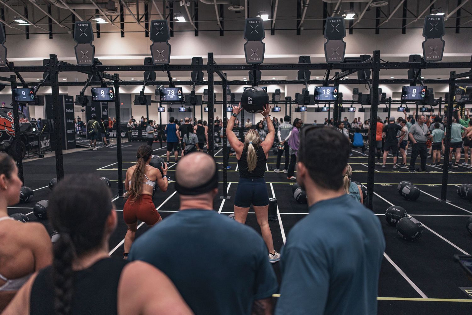 Wide view of modern gym facility with multiple workout stations and training equipment.