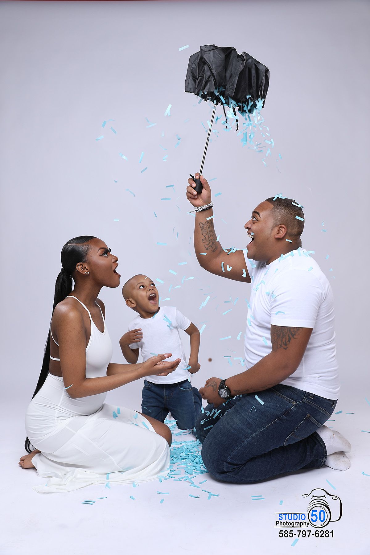 Family photo session with blue confetti and playful expressions.