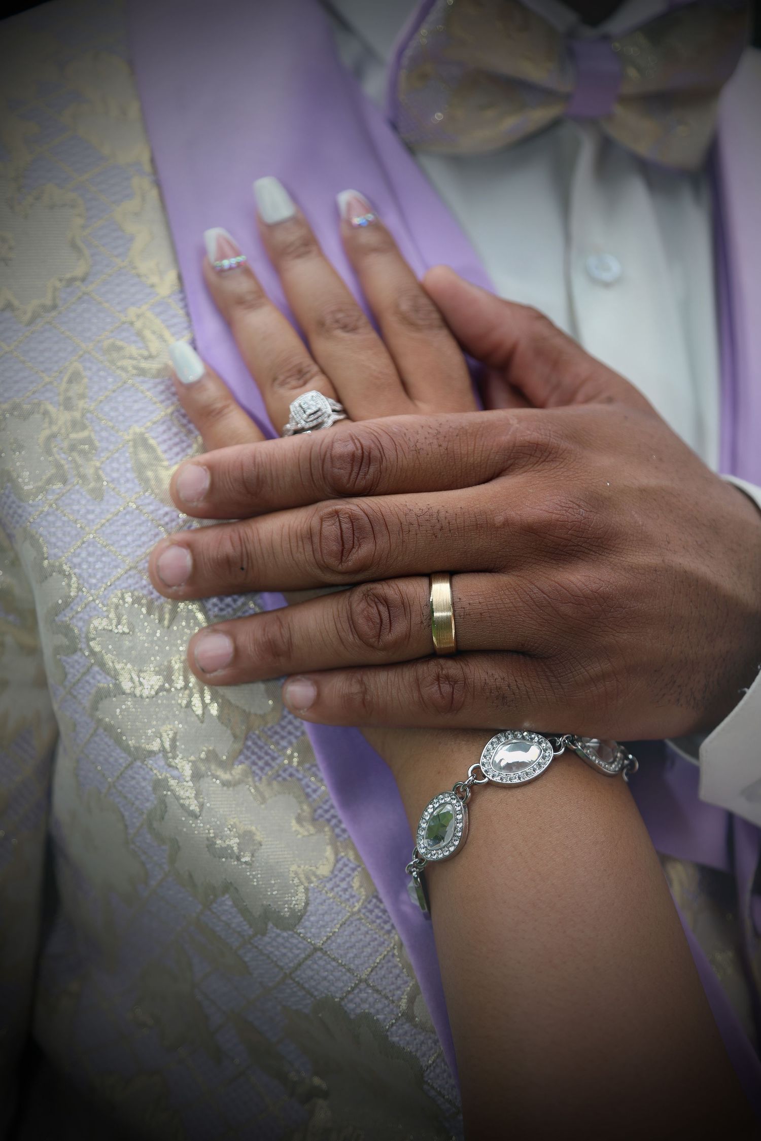 Close-up shots of wedding rings and jewelry against lace fabric.