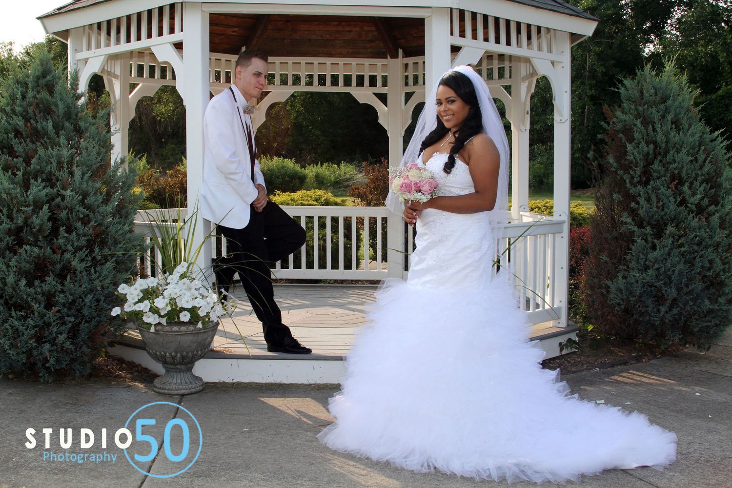 Romantic wedding photos taken at a white gazebo in a garden setting.