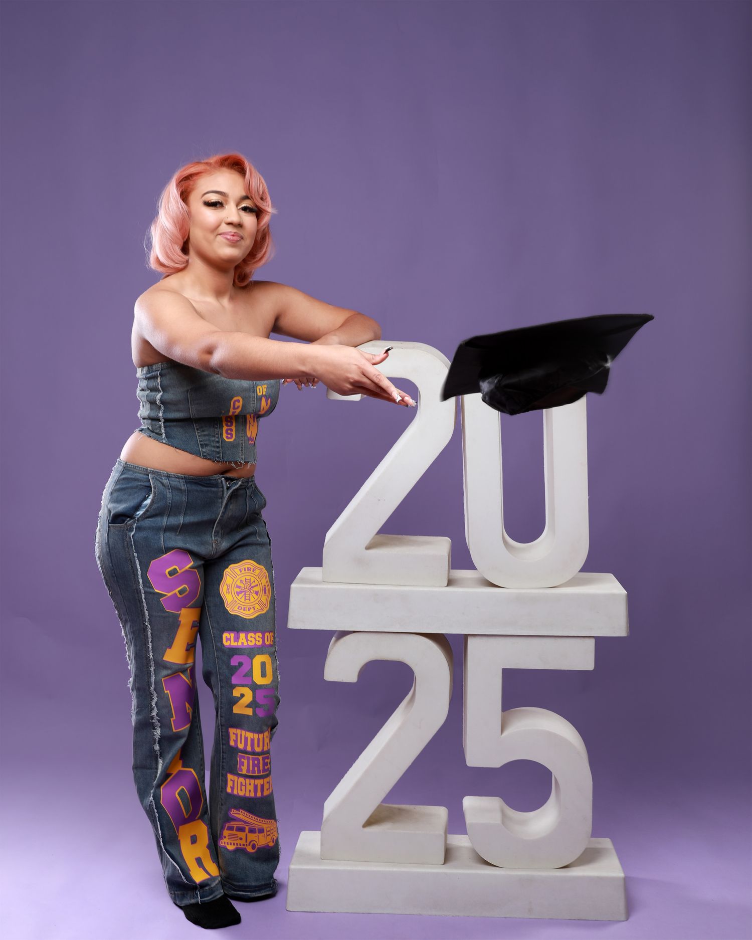Senior portrait series with large white 2025 numbers against purple backdrop.
