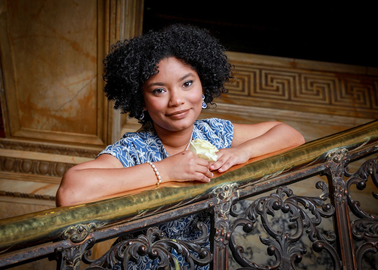 Elegant portrait series along ornate railing in classic architectural setting.