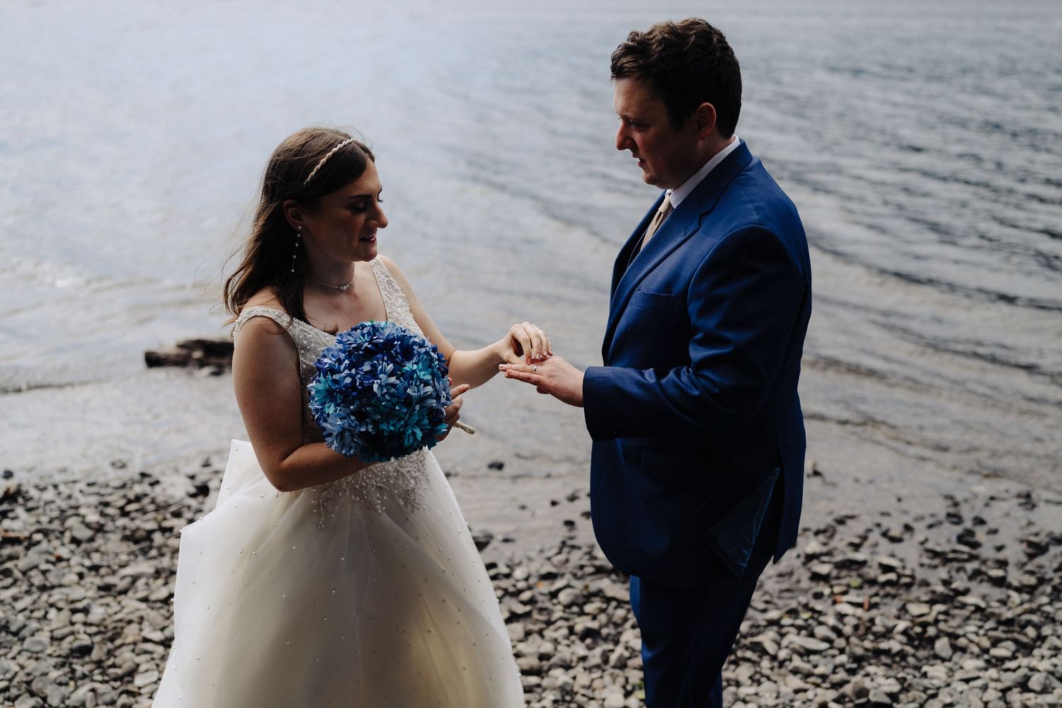 An intimate lakeside wedding ceremony with mountains and water in the background.