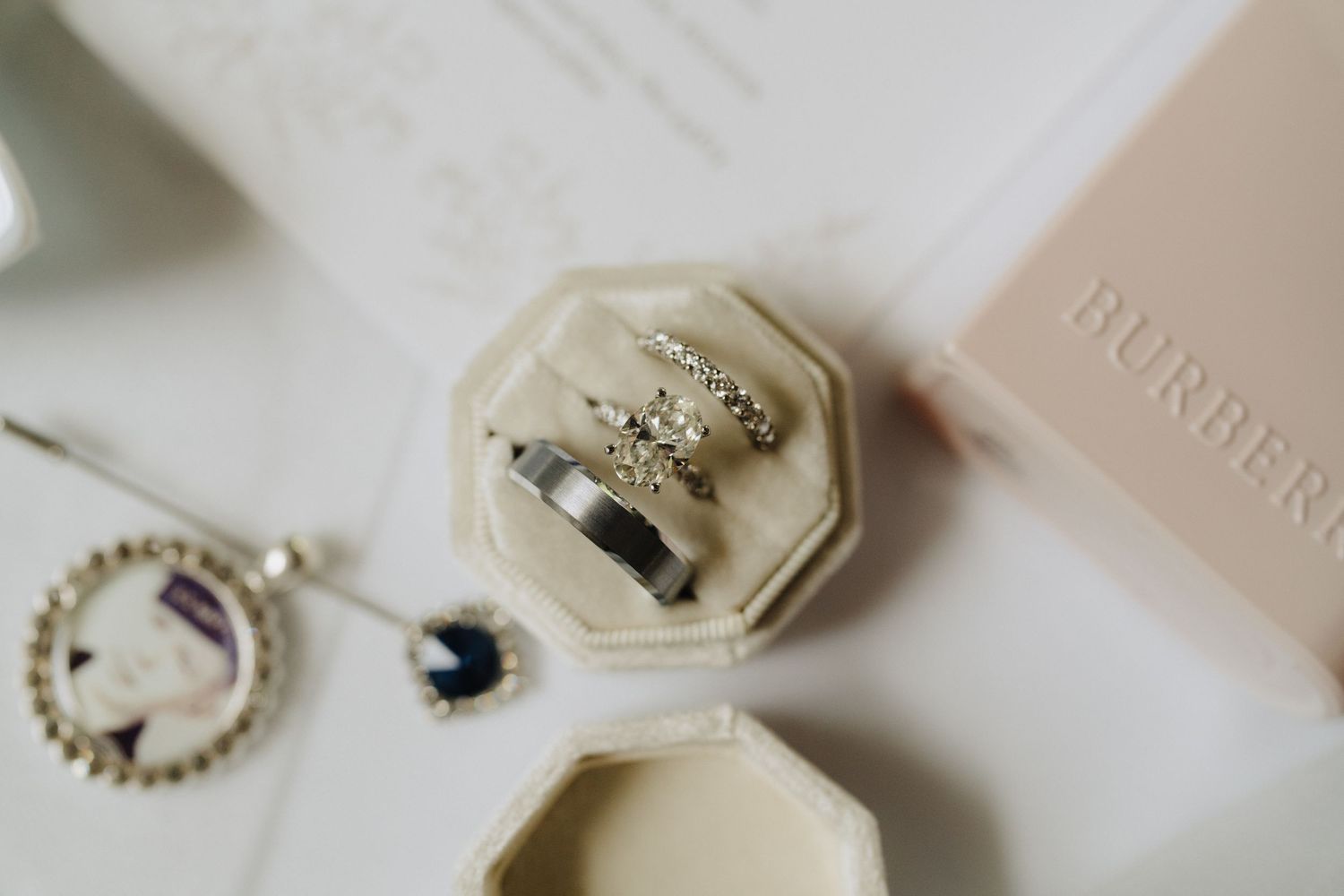 Wedding accessories including rings, jewelry, and decorative items arranged on a light surface.