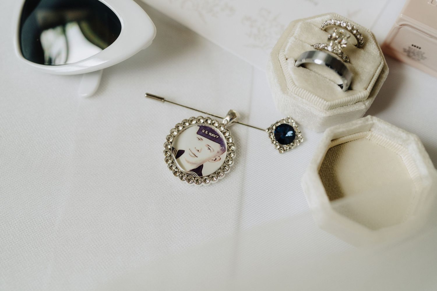 Wedding detail shots of rings, jewelry and delicate white accessories arranged on a light surface.