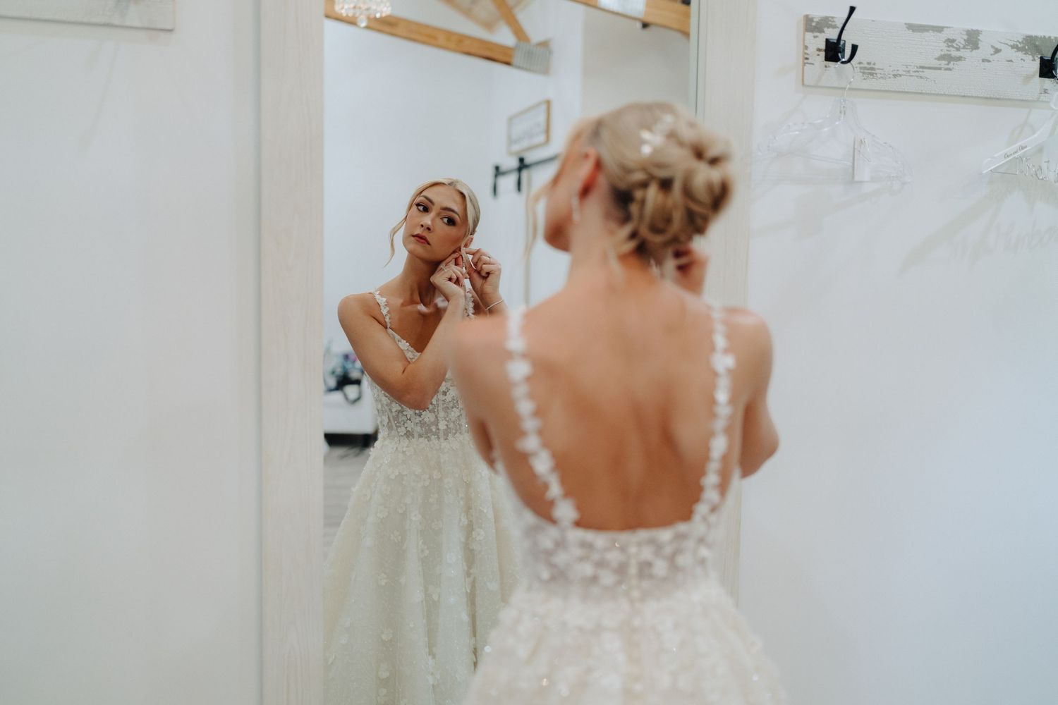 Getting ready shots show elegant wedding dress details and preparations in a light-filled room.