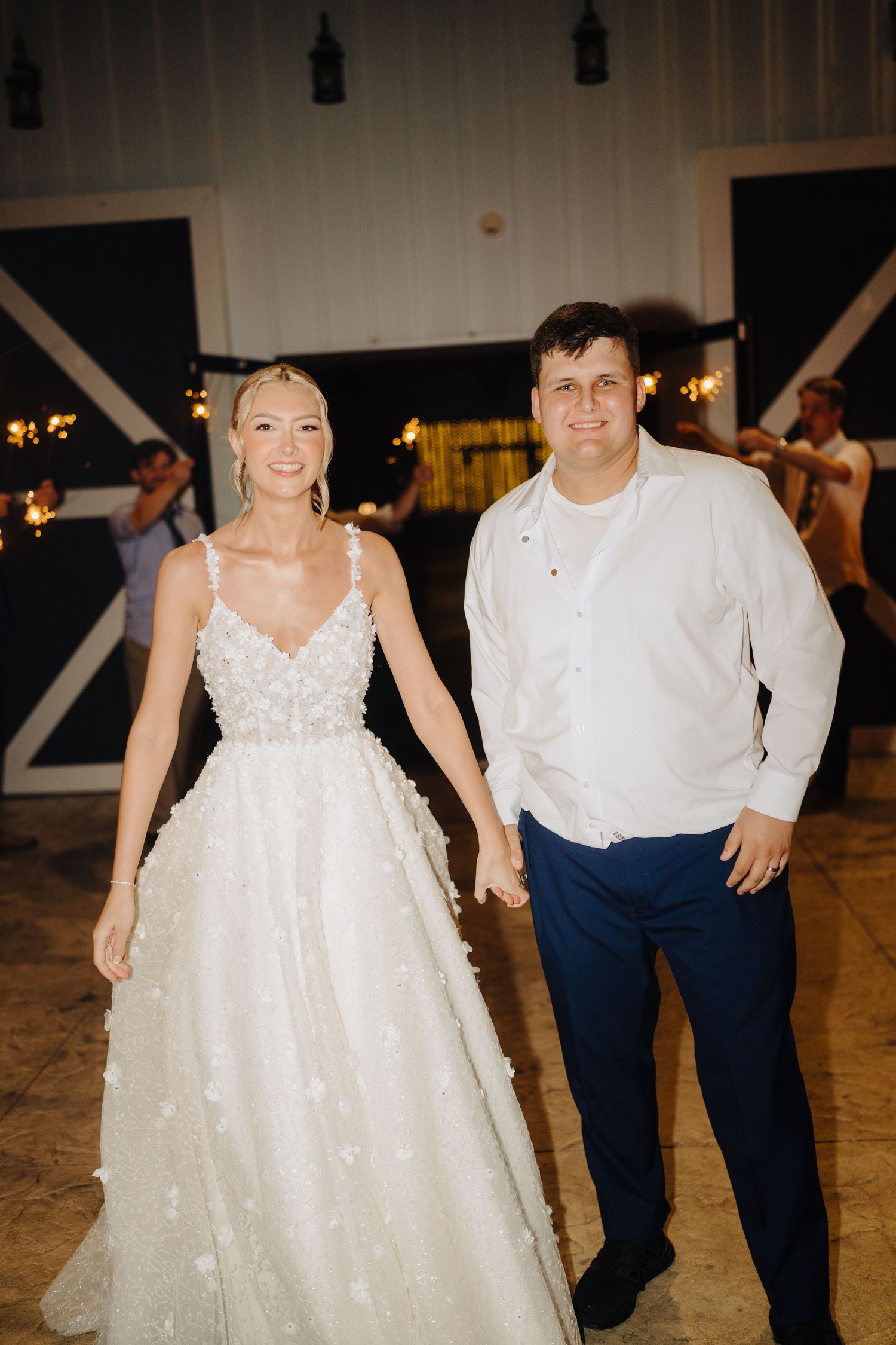 Wedding couple dancing in reception venue with sparkly dress and navy attire.
