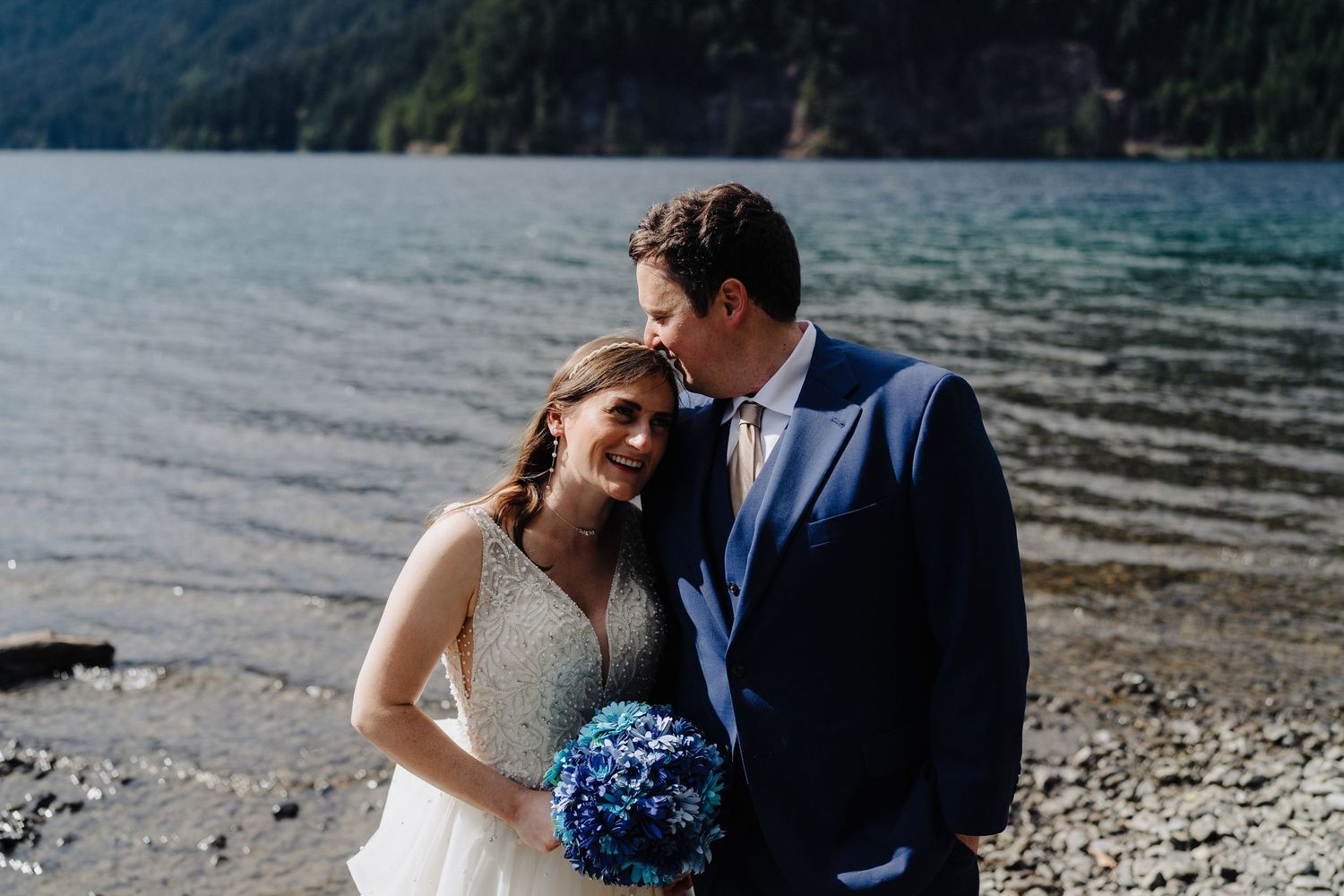 A tender moment between a couple by a serene mountain lake.