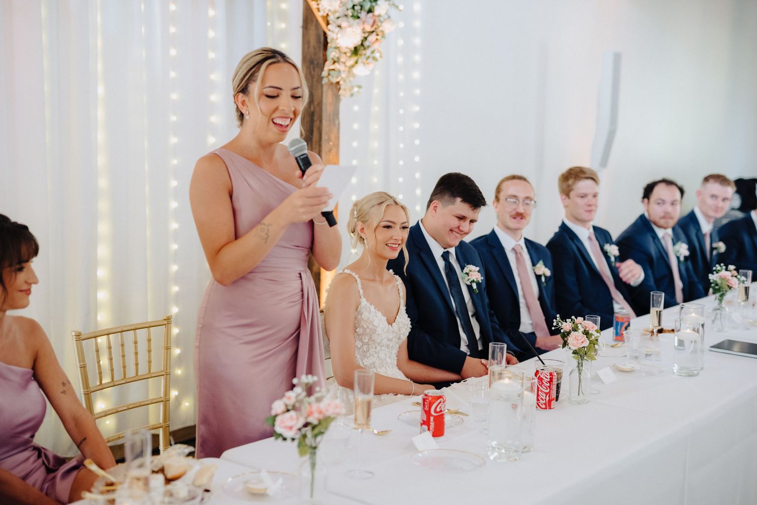 Wedding reception table with guests dining and celebrating.