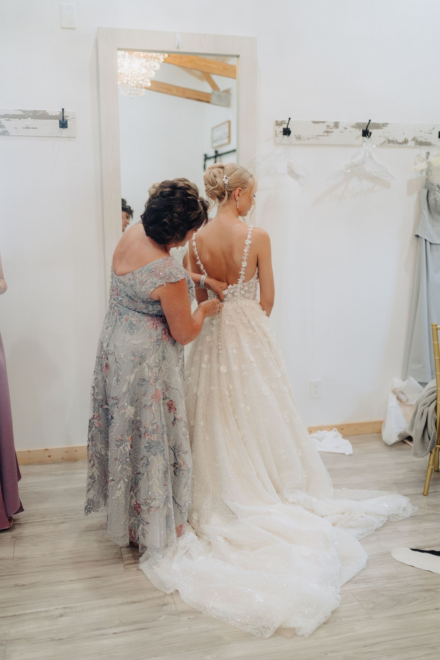 A wedding dress fitting session shows detailed lace work and a flowing train.