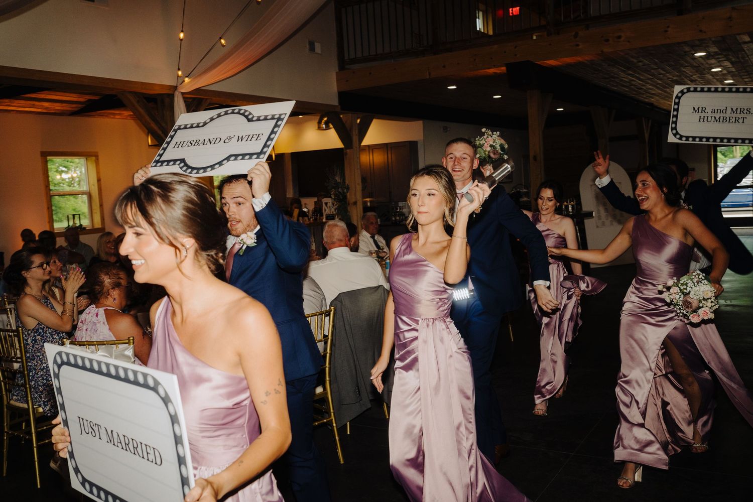 Wedding reception dance floor with guests dancing in mauve bridesmaid dresses.