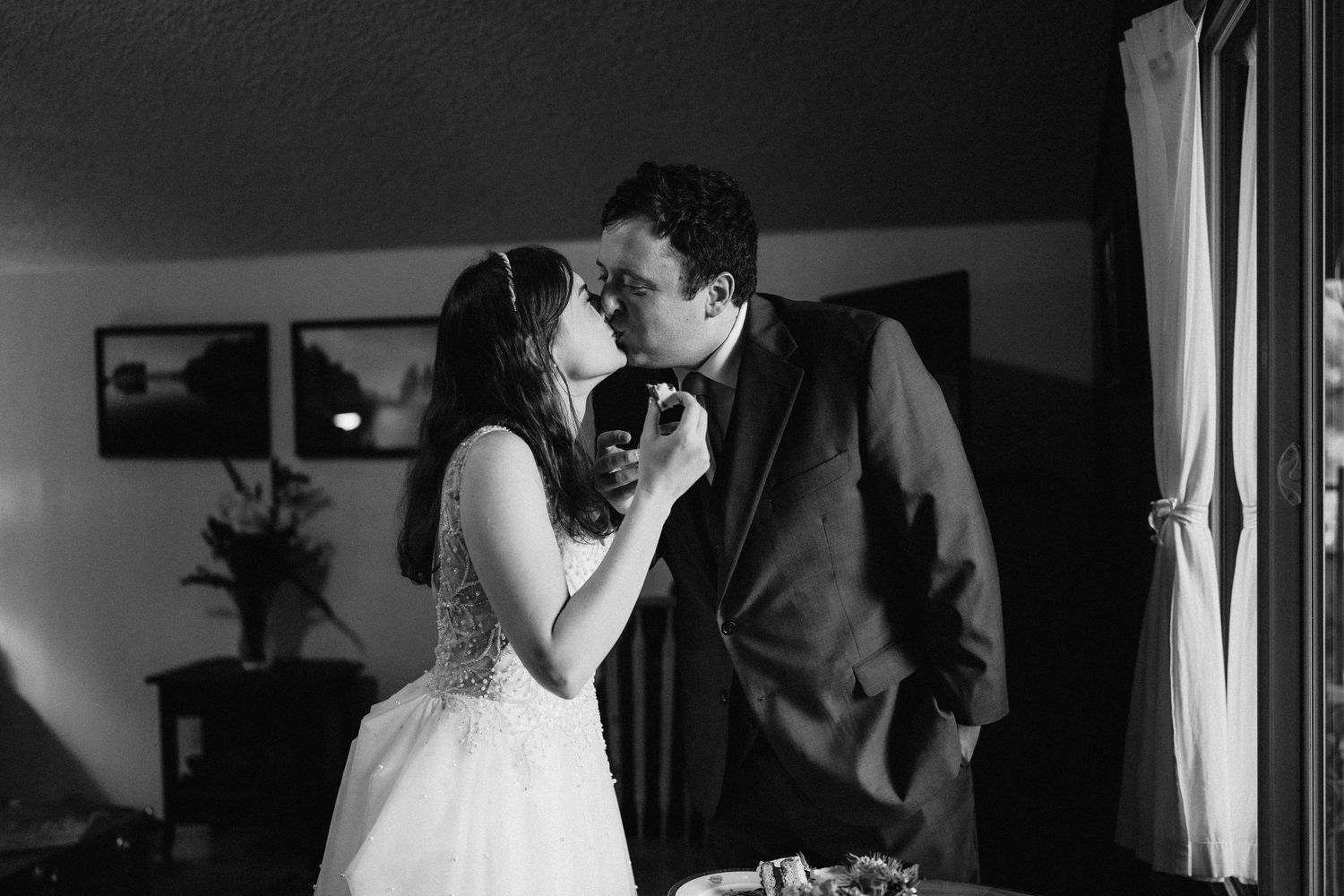 An intimate black and white wedding photo showing a tender indoor moment.