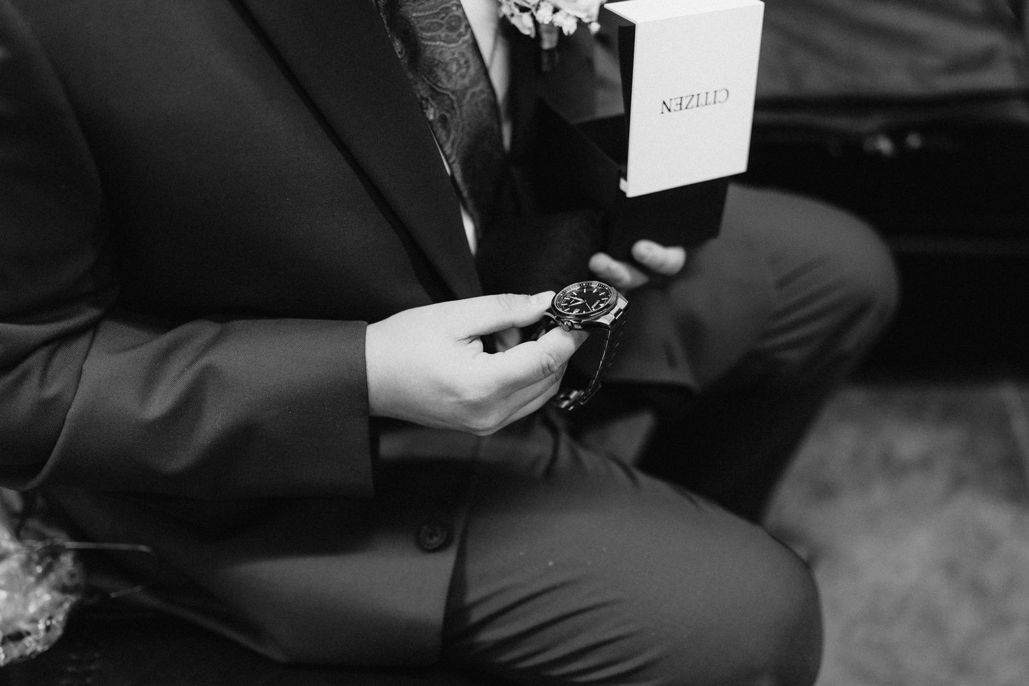 Close-up of hands adjusting formal attire during wedding preparations.