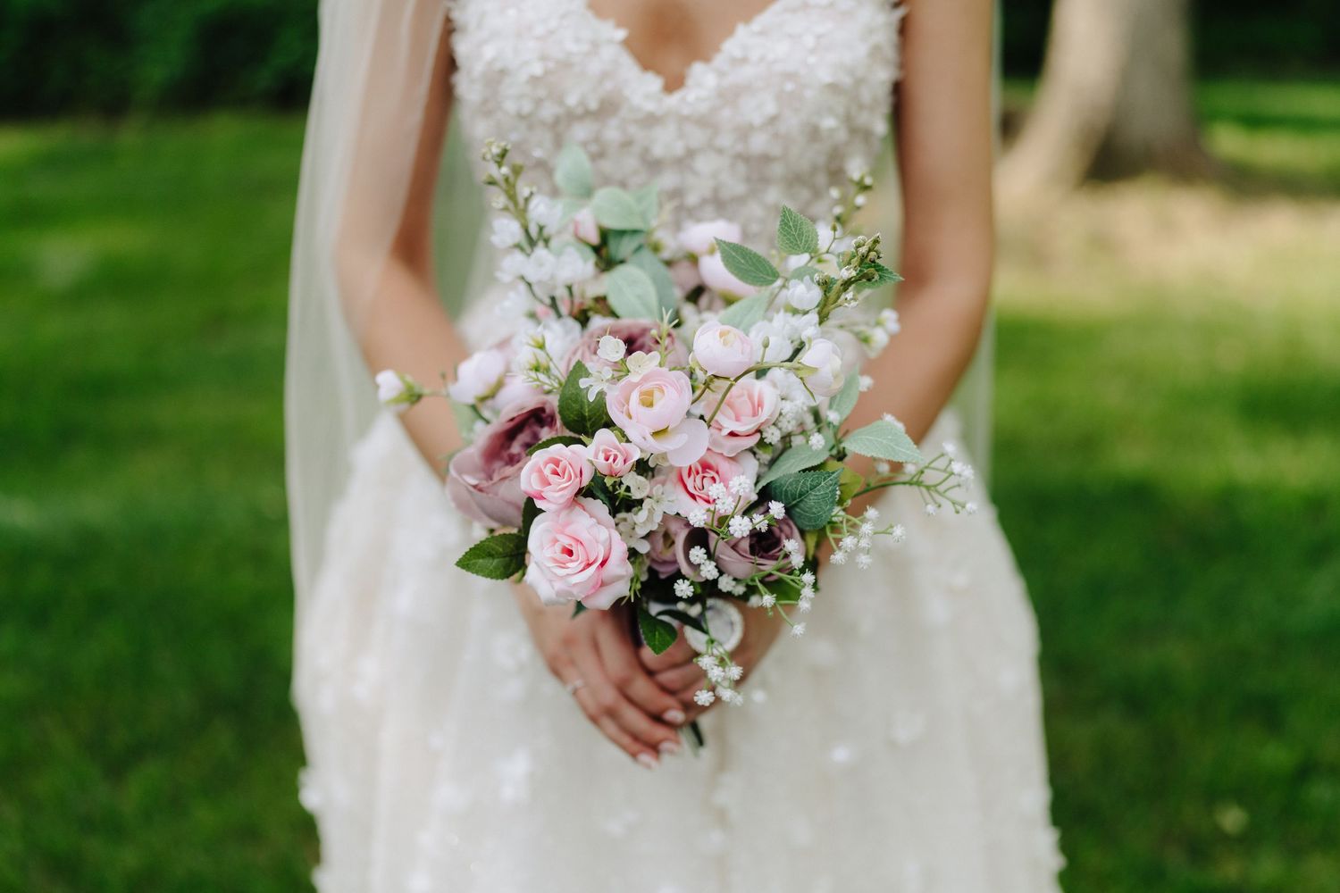 Bridal bouquet features soft pink roses and mixed flowers in romantic garden style.