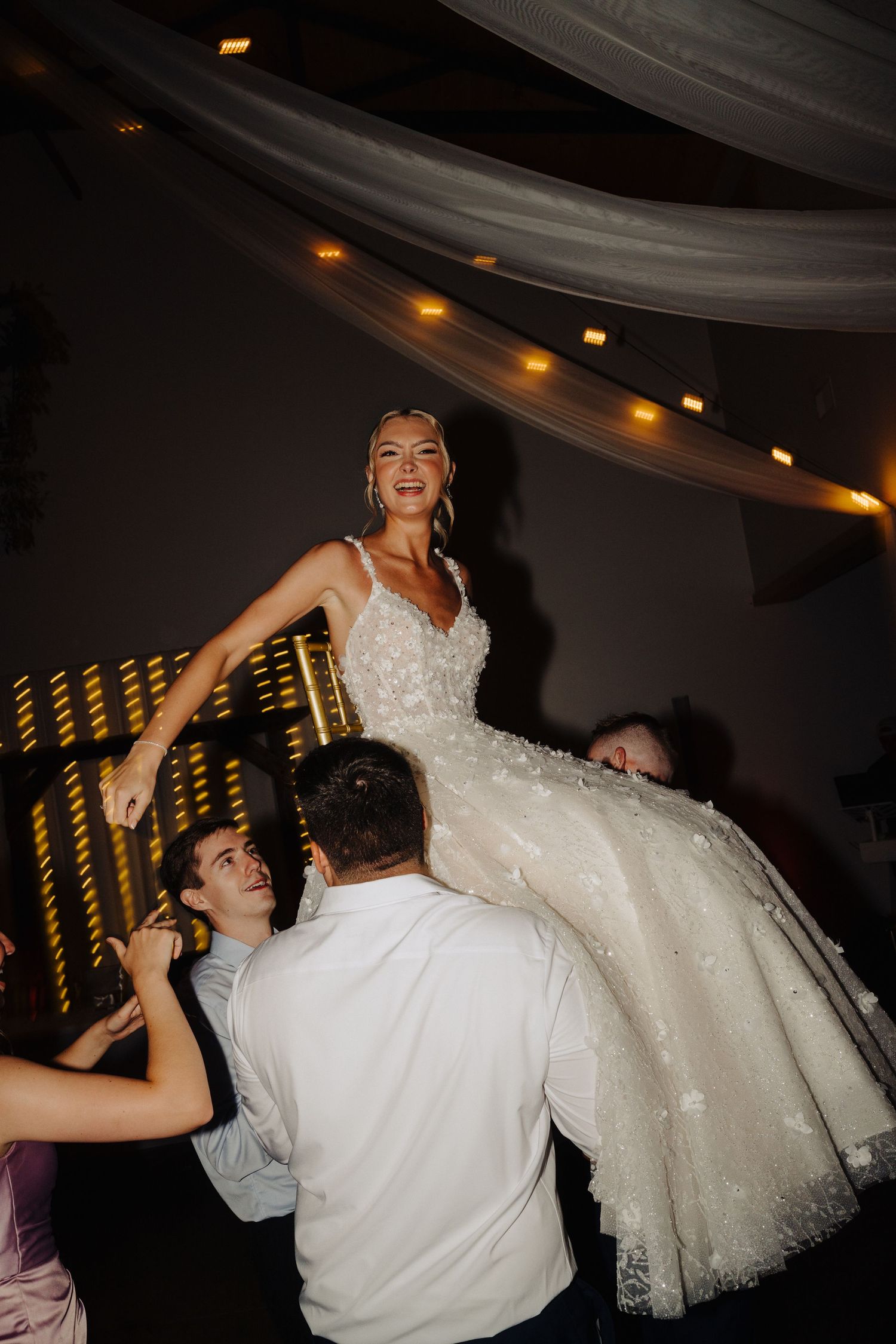 Newlyweds dance together during their wedding reception as the bride's white ballgown dress swirls on the dance floor.