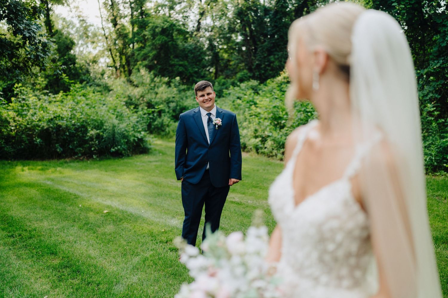 Wedding portraits taken in a vibrant green garden setting with natural lighting.